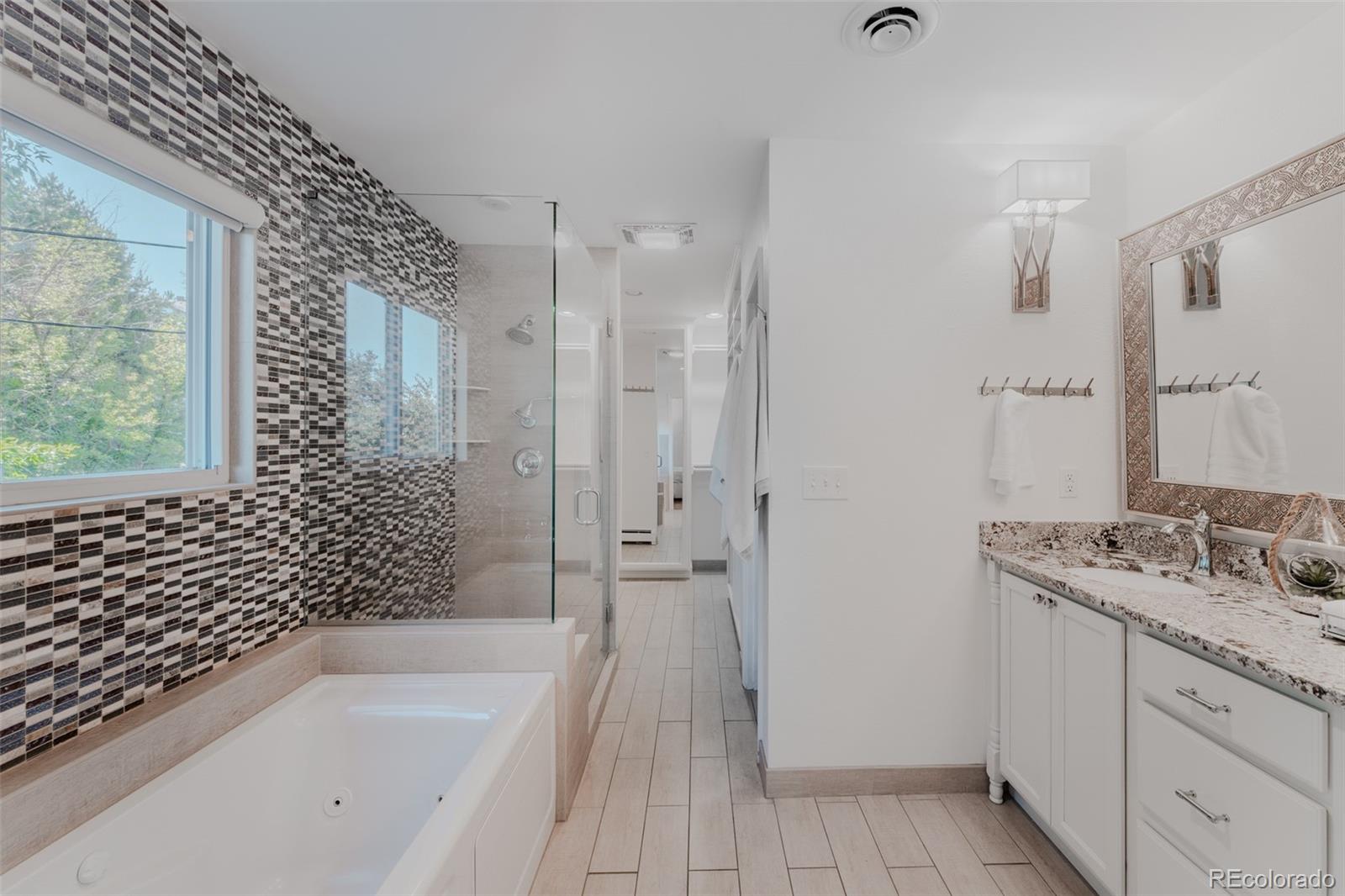 The primary ensuite bath is a serene sanctuary, showcasing dual vanities, a spacious shower, and a generously sized soaking tub equipped with a handheld sprayer.