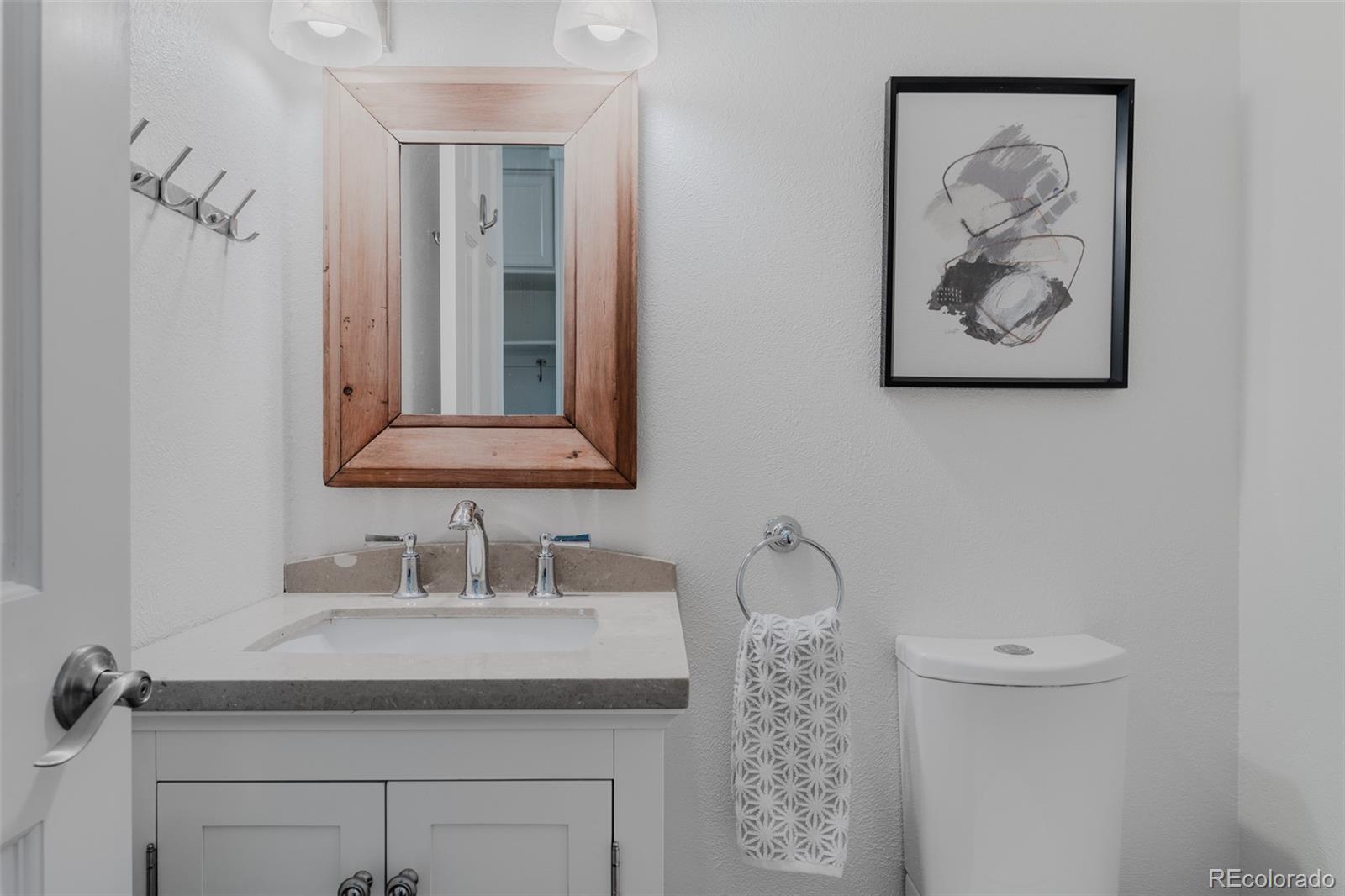 The powder bath features a minimalist design with clean lines, a simple yet elegant vanity, and understated fixtures, creating a serene space.