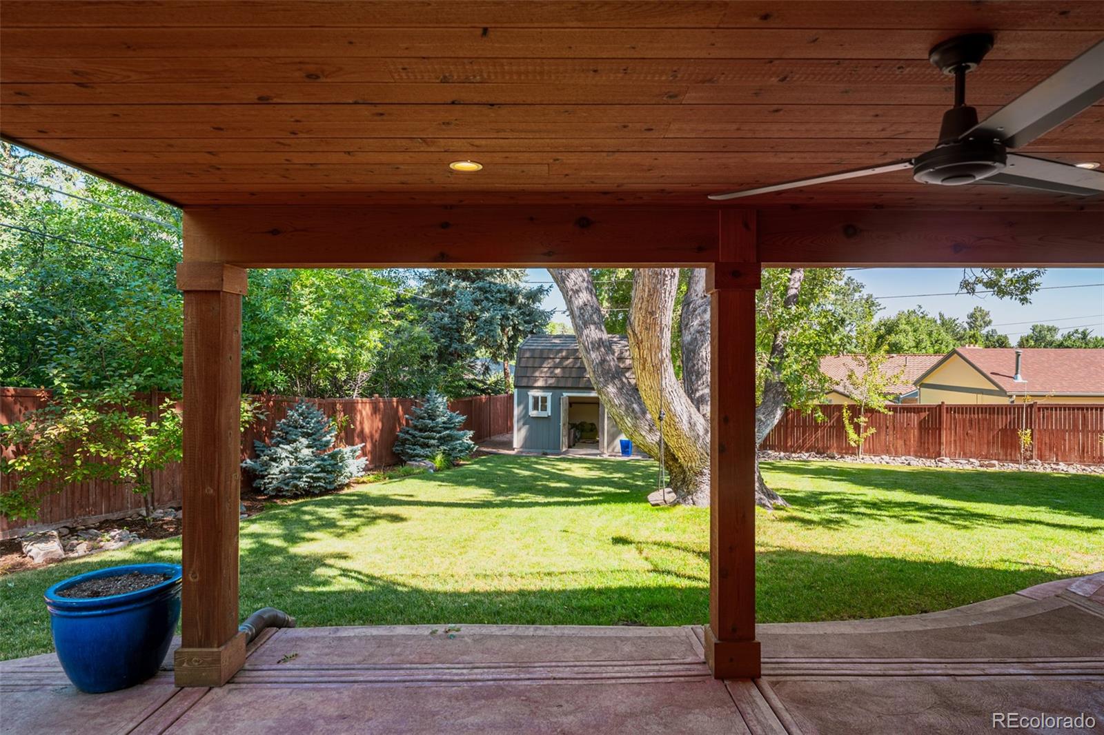 Walk right out onto the patio, shaded by a timber-framed roof and cooled by a ceiling fan, creating a comfortable and inviting outdoor retreat.