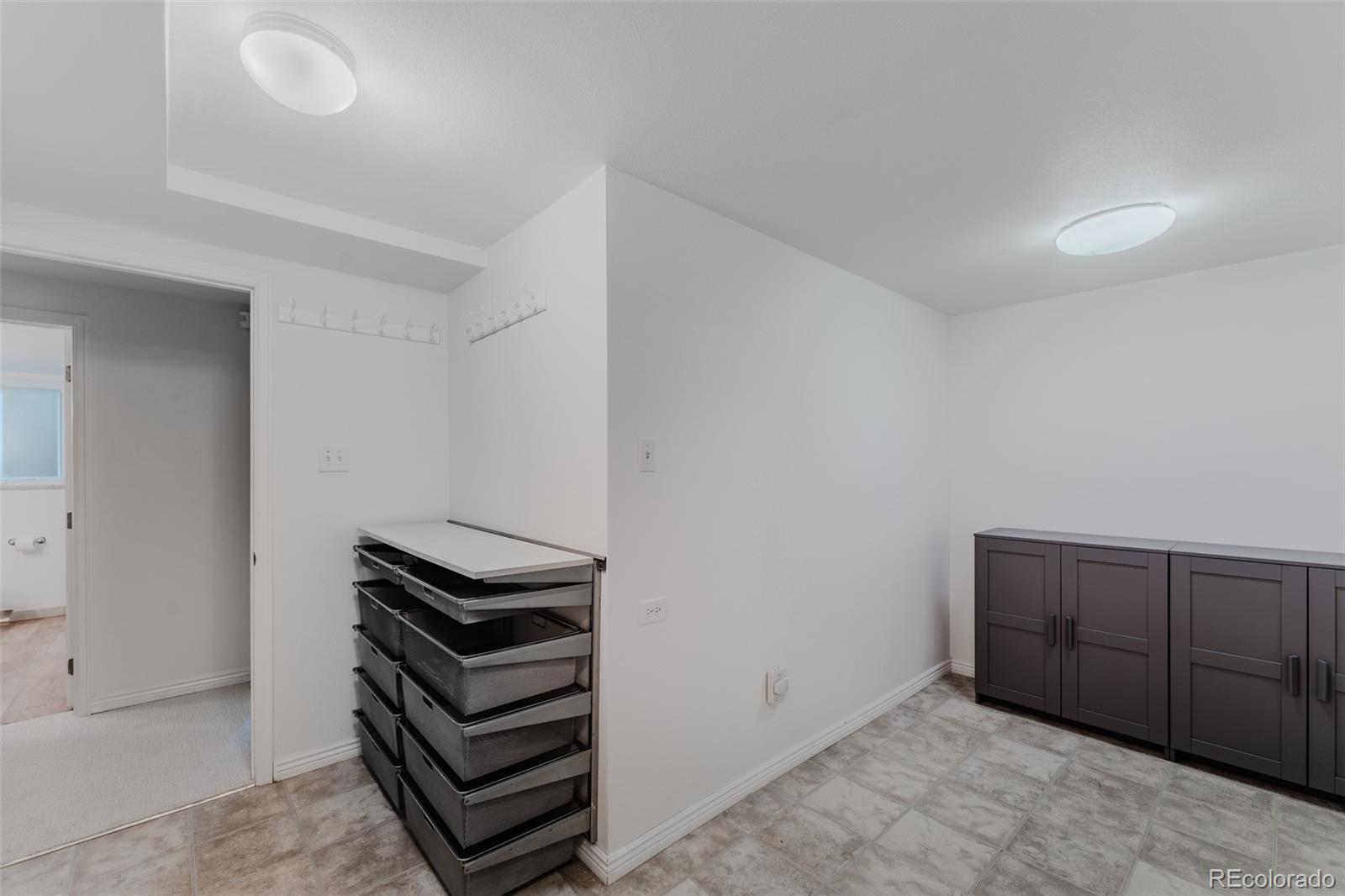 The basement laundry area with included washer and dryer is spacious, featuring built-in drawers and cabinets to ensure everything has its place.