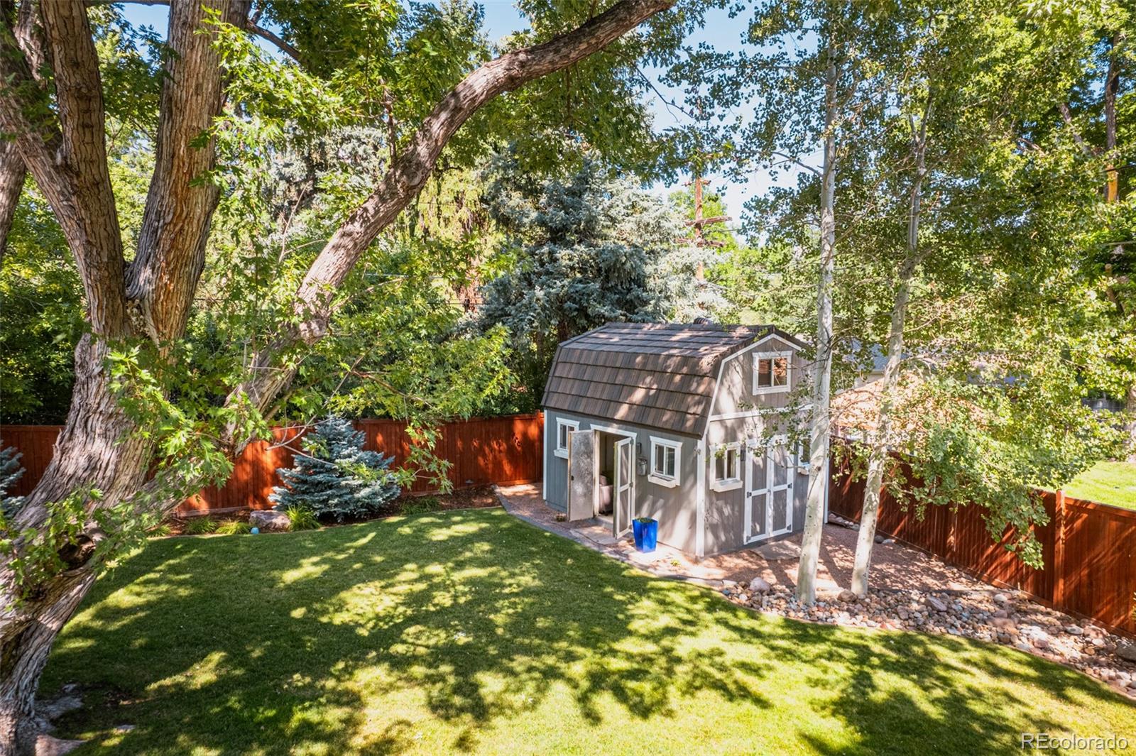 A charming barn style outdoor shed beckons for projects or play, offering a charming and spacious hideaway.