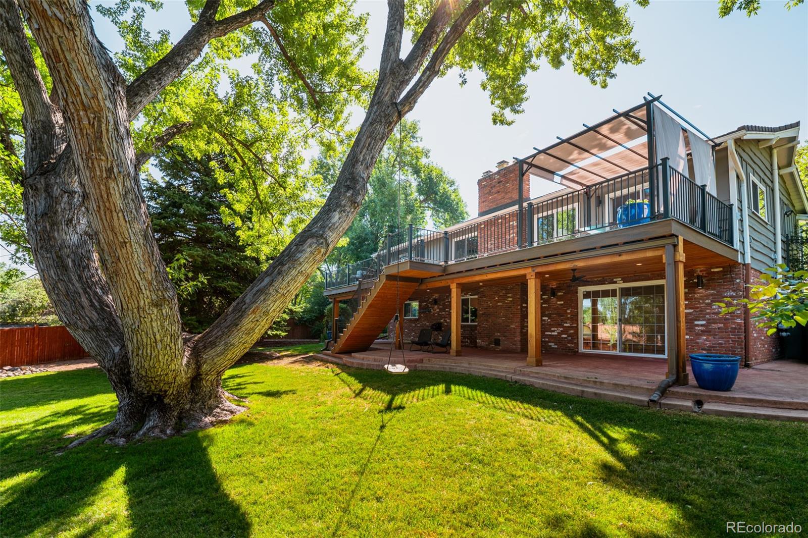 A majestic mature tree with sprawling branches stands proudly in the middle of the backyard, offering a serene canopy of shade and a timeless connection to nature.