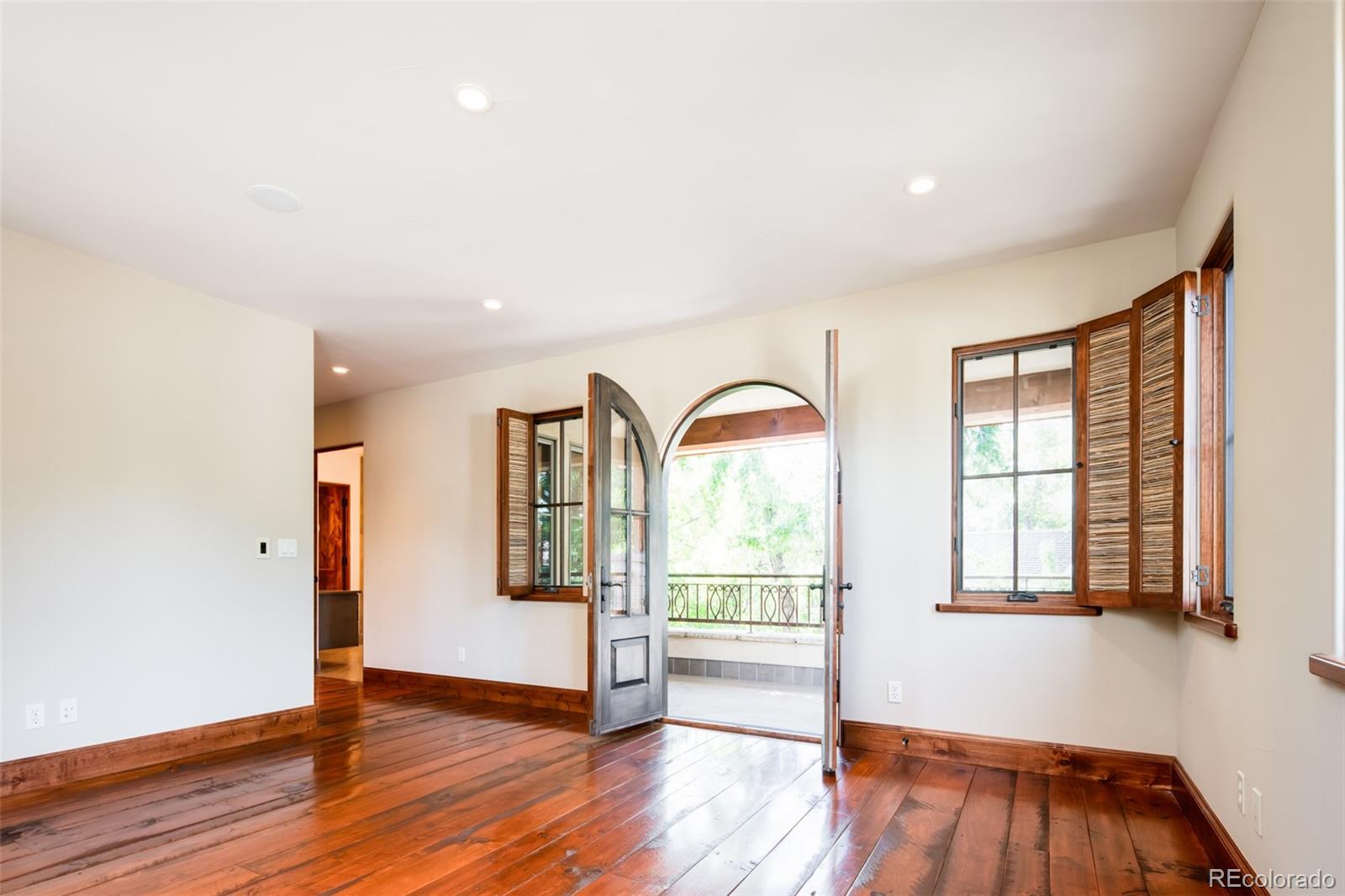 Primary Bedroom with Arched French Doors to Private Balcony