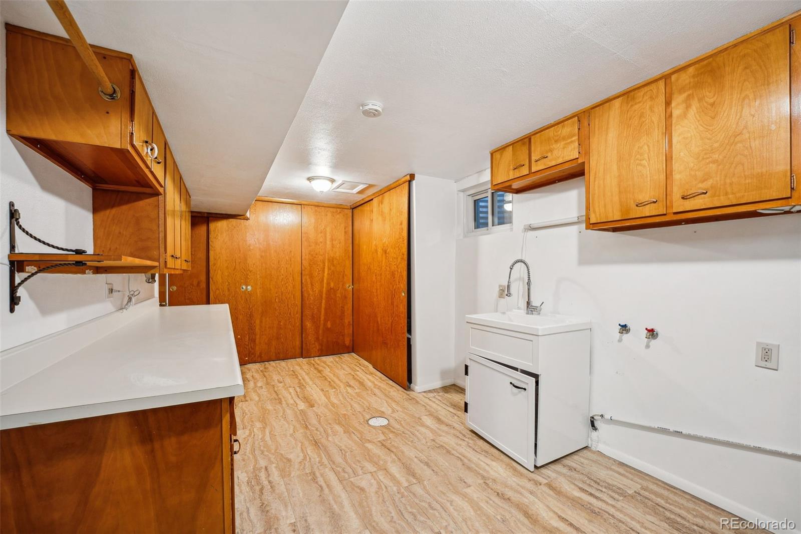 Laundry room with great storarage closets and cabinets and utility sink