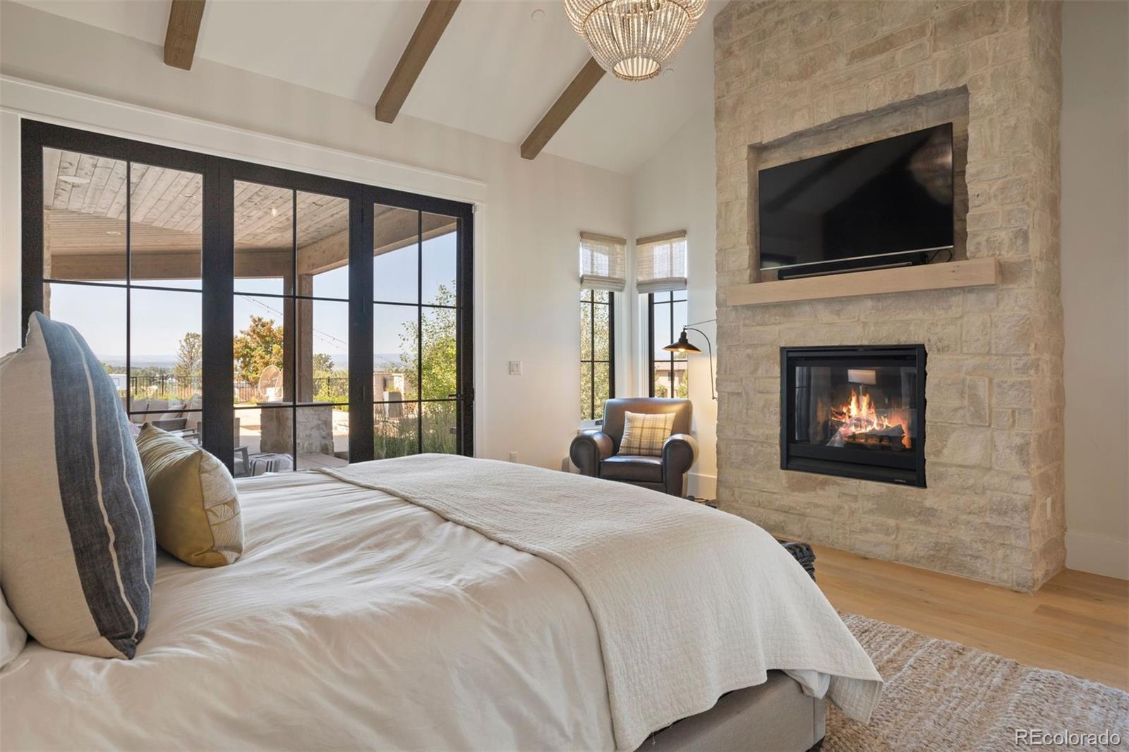 Primary suite's fireplace with natural stone and white oak.