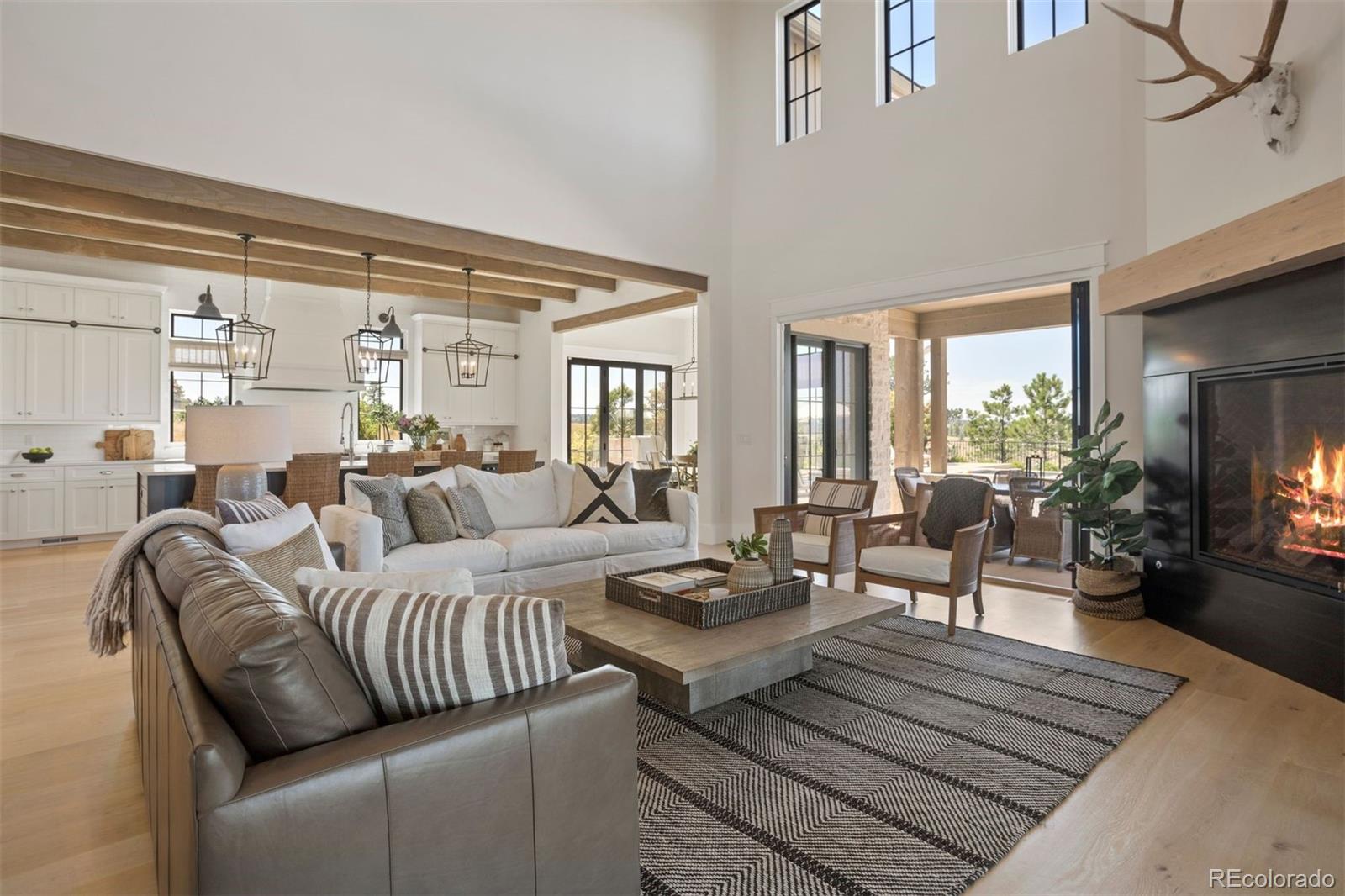 22' ceiling with Restoration Hardware® iron chandelier and oversized fireplace with custom metalwork and white oak mantel.