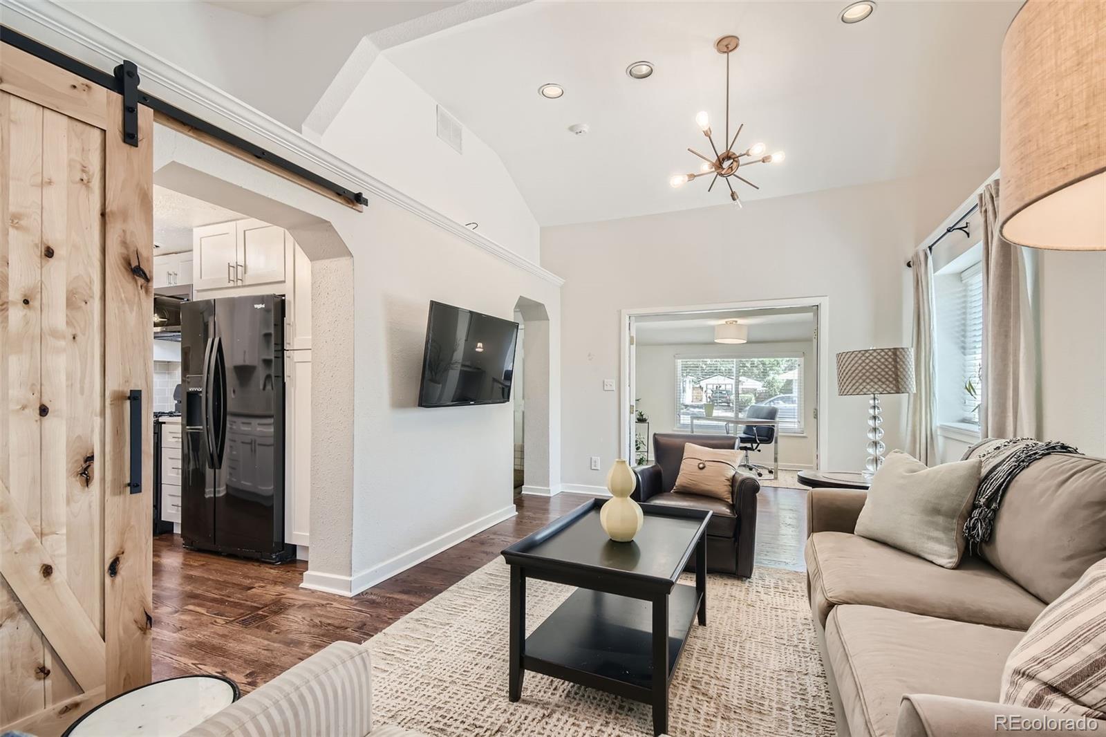 Family Room with vaulted ceiling, custom barn door, and private office with French doors.