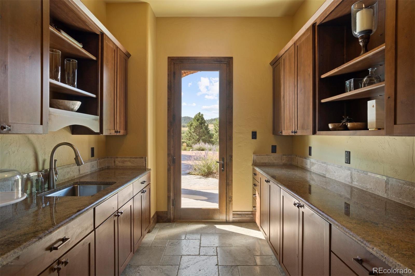 Large walk-in pantry with sink, extra freezer, and an exterior door for easy grocery unloading.