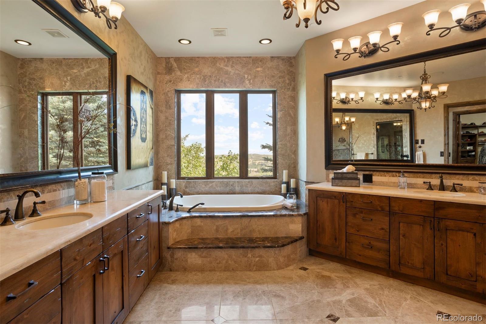 Primary bathroom with soaking tub, marble vanities, and large walk-in shower.