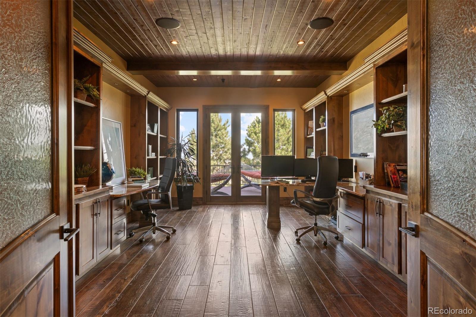 The office features built-in bookshelves and two desks.