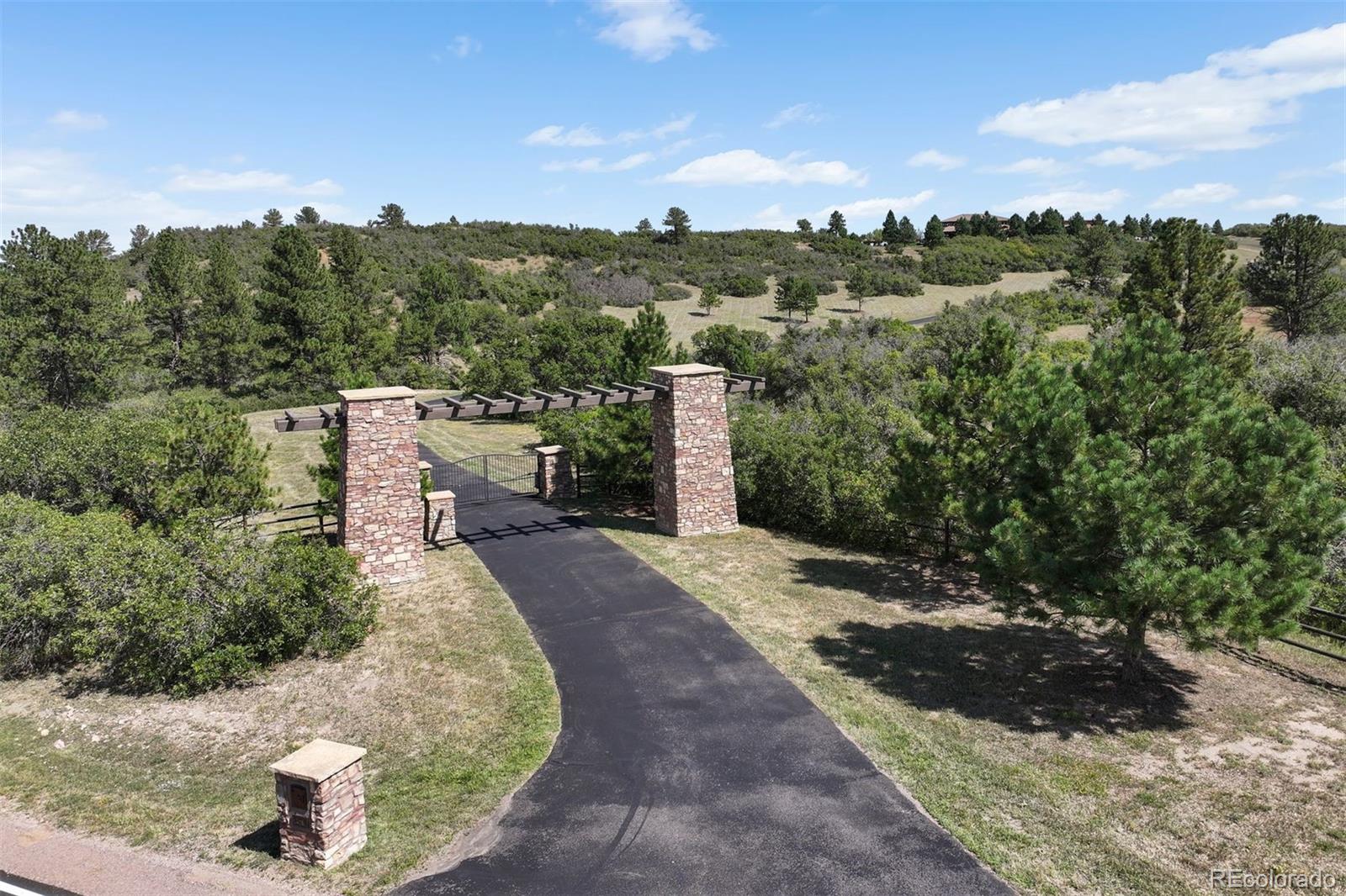 A gated entry opens to a circular drive leading to a spectacular structure.