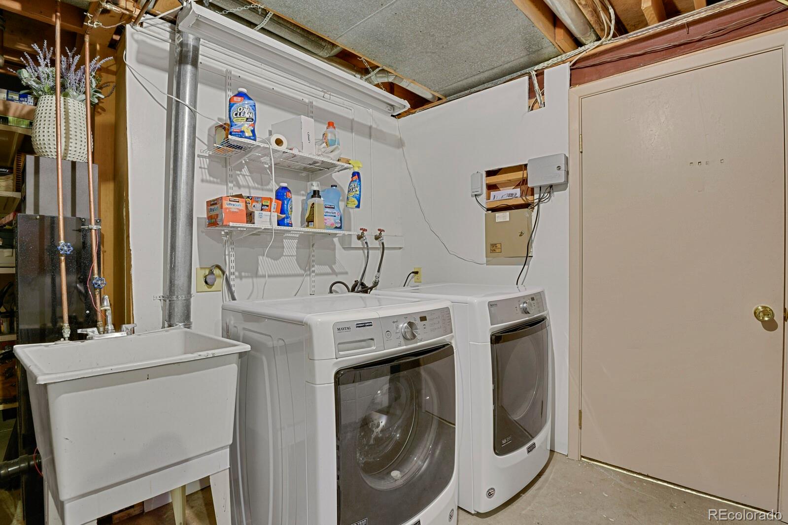 current laundry area with tons of storage and shelving