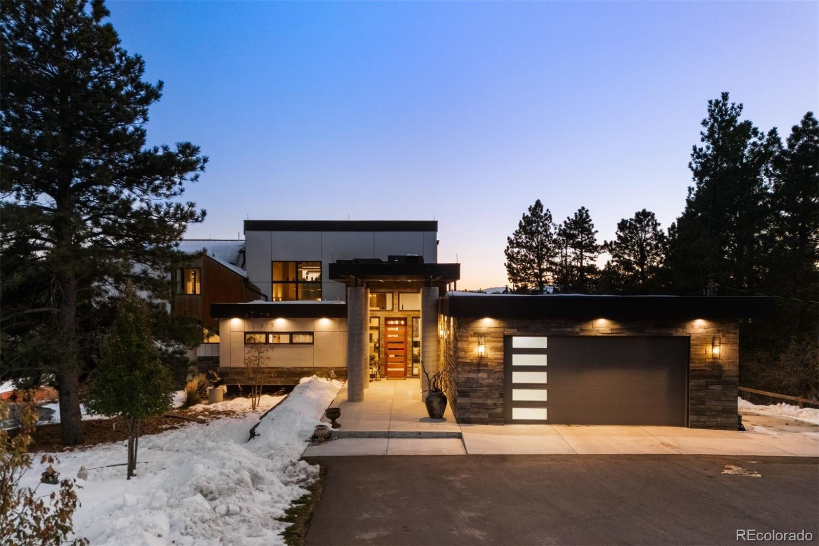 The outside walkway features cement pillars, cement siding that looks like wood, and a steel awning.