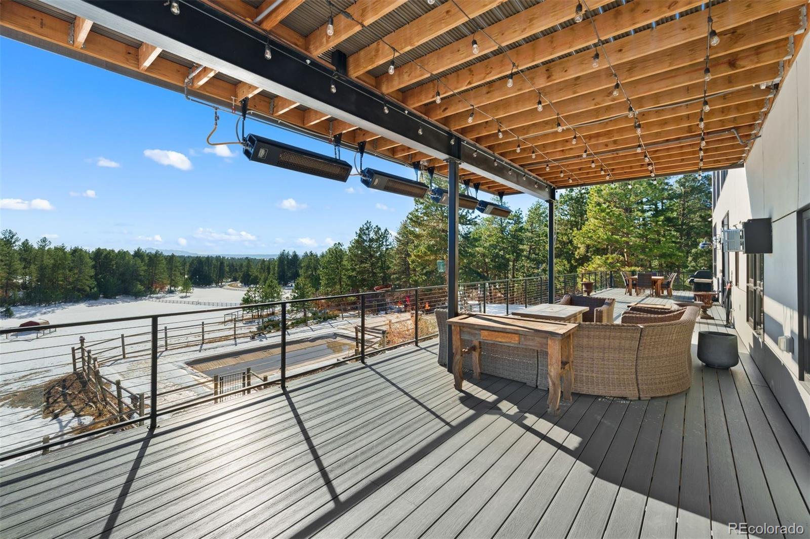 Full-length deck with multiple sitting areas and a covered heated pergola.