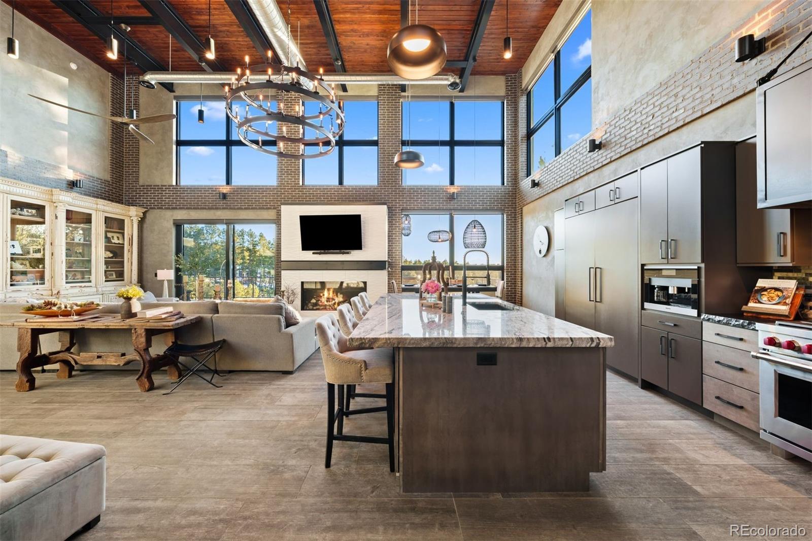 The voluminous great room is crowned by a soaring 22-foot Douglas Fir ceiling, with exposed steel beams and air ducts that underscore its bold industrial character.