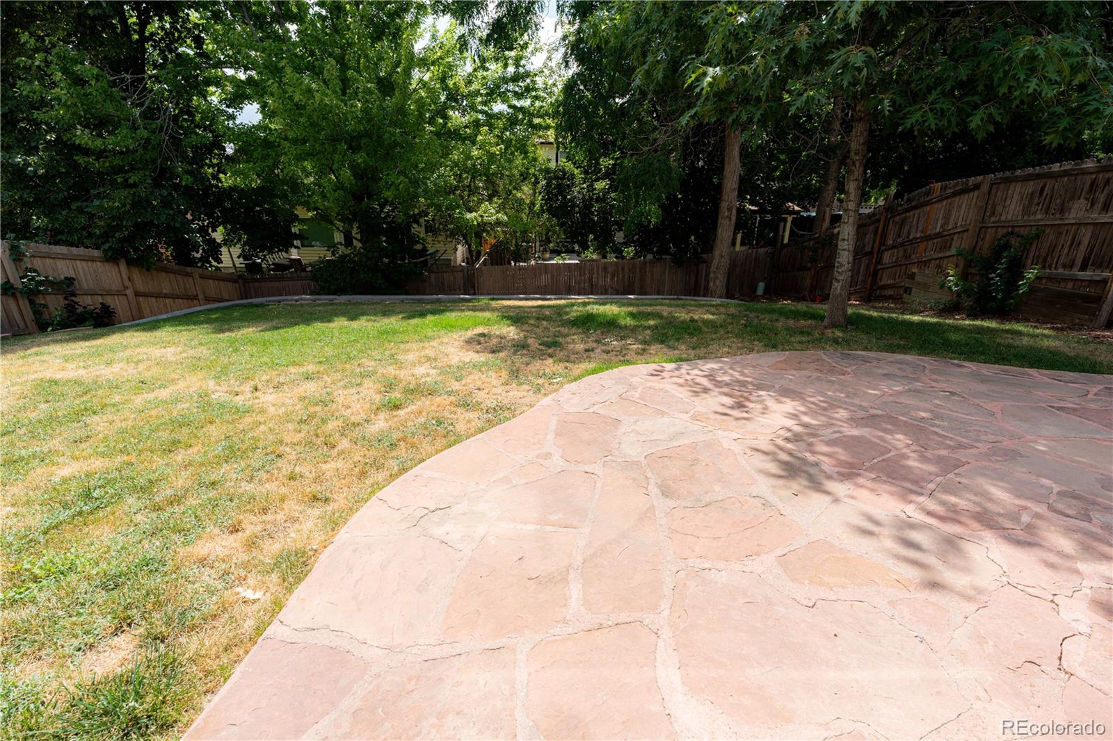 Private fenced backyard with flagstone patio