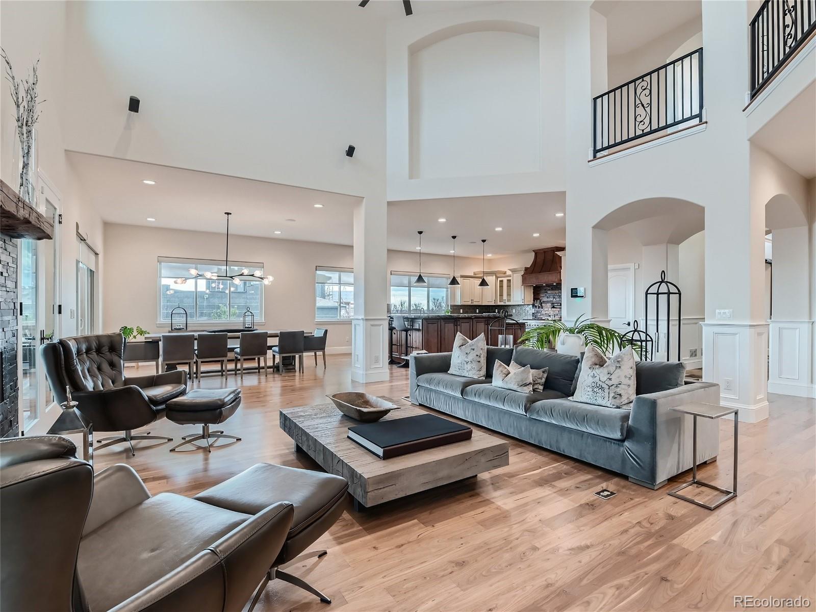 Luxury estate has great room with dramatic two-story ceiling, walnut hardwood floors, linear fireplace, hidden pop-up under floor tv lift, Lutron blinds, lights, Sonos sound system, wall of glass doors opening to an extensive outdoor area.