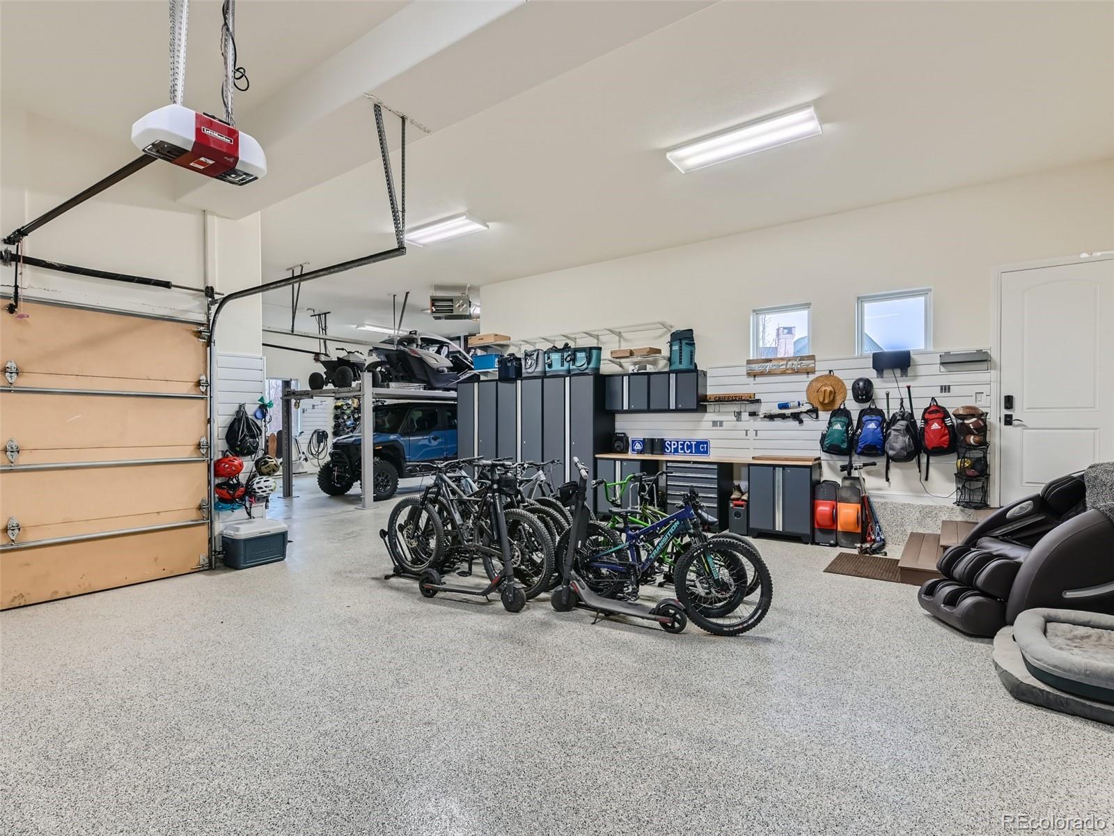 Massive garage with high ceilings, epoxy floors, EV charging, built-in cabinets, counters, shelving, overhead storage, space for five cars, toys and more.