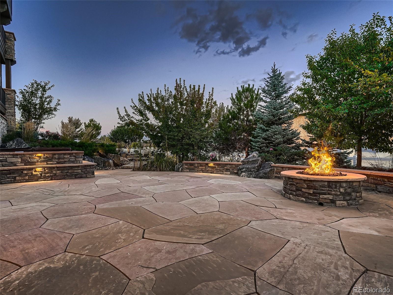 Extensive indoor-outdoor living, private outdoor retreat, stone patio with gas firepit water feature, hot tub adjacent to walk-out lower level.