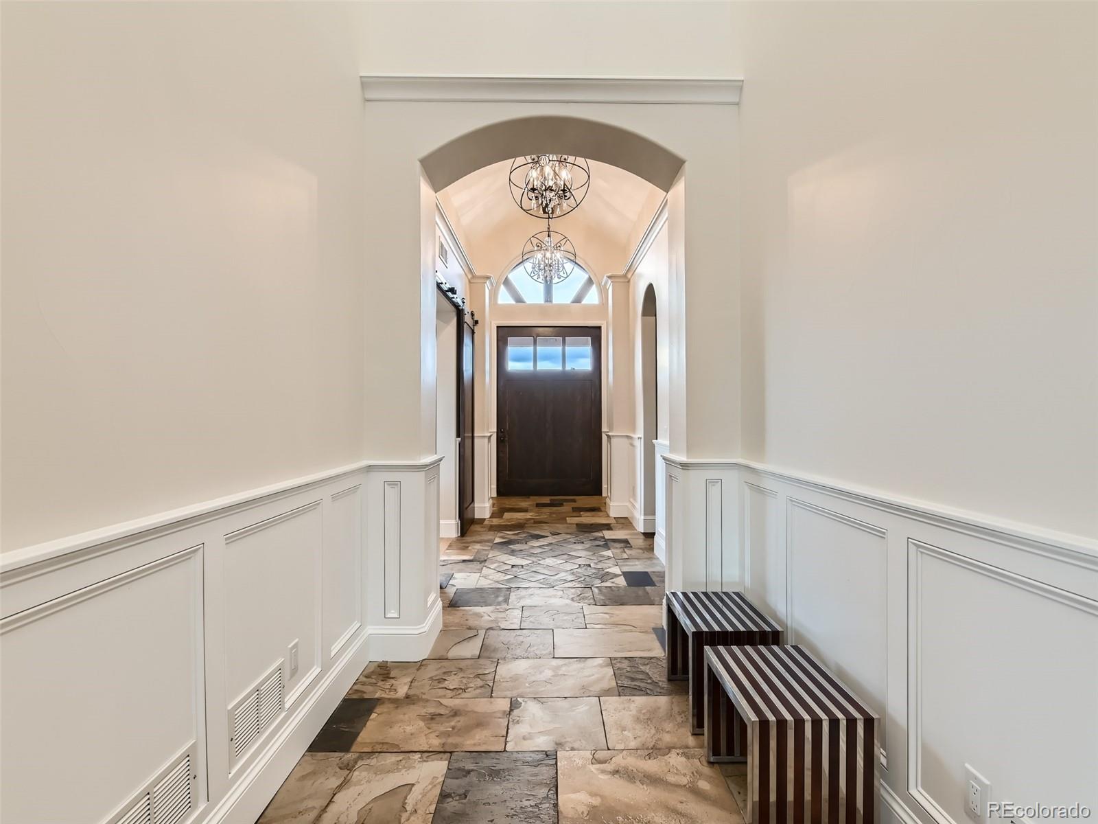 Grand entry foyer showcases a huge custom front door on pivot system