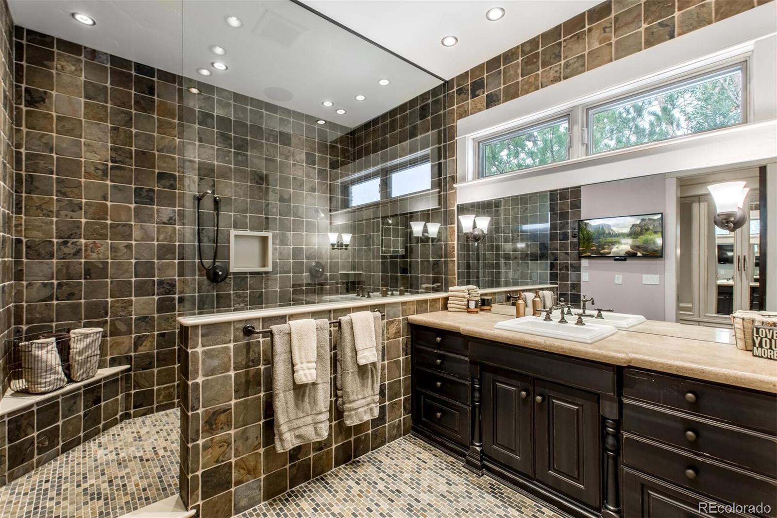 A very detailed and masculine private men's bathroom with massive walk-in shower, stately vanity area and huge walk-in closet.