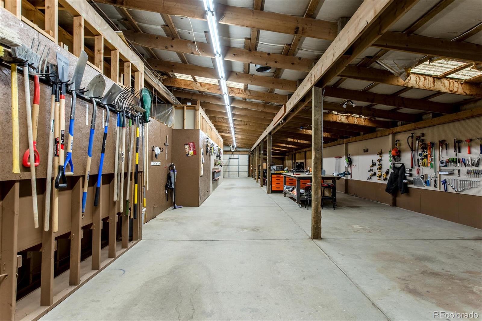 A true dream garage! Large doors can be opened at either side, making storing and working here a breeze. This building has heat, water and room for anything you desire. The other side of the barn is the stable/dog kennel. There are multiple doors and fence