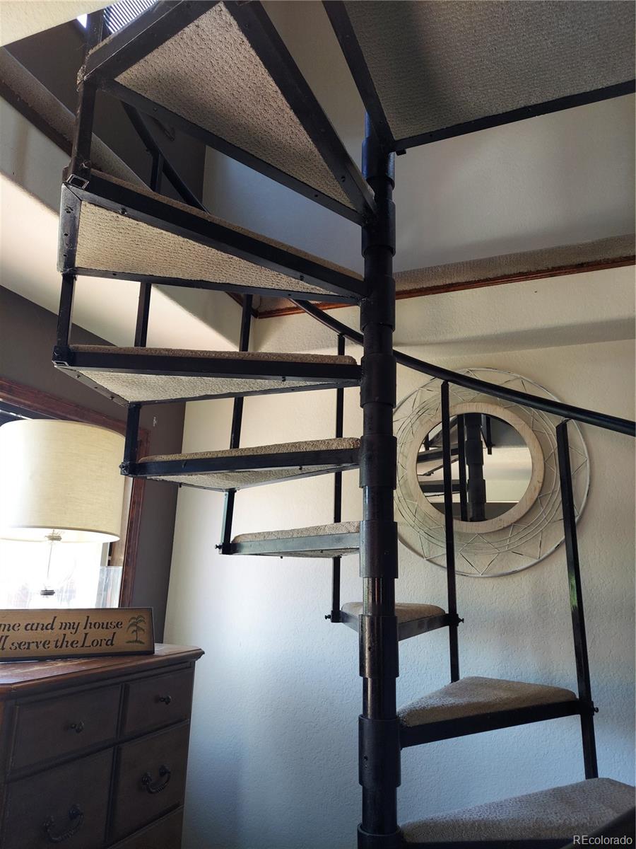 Spiral staircase leading to Loft Bedroom above garage area.