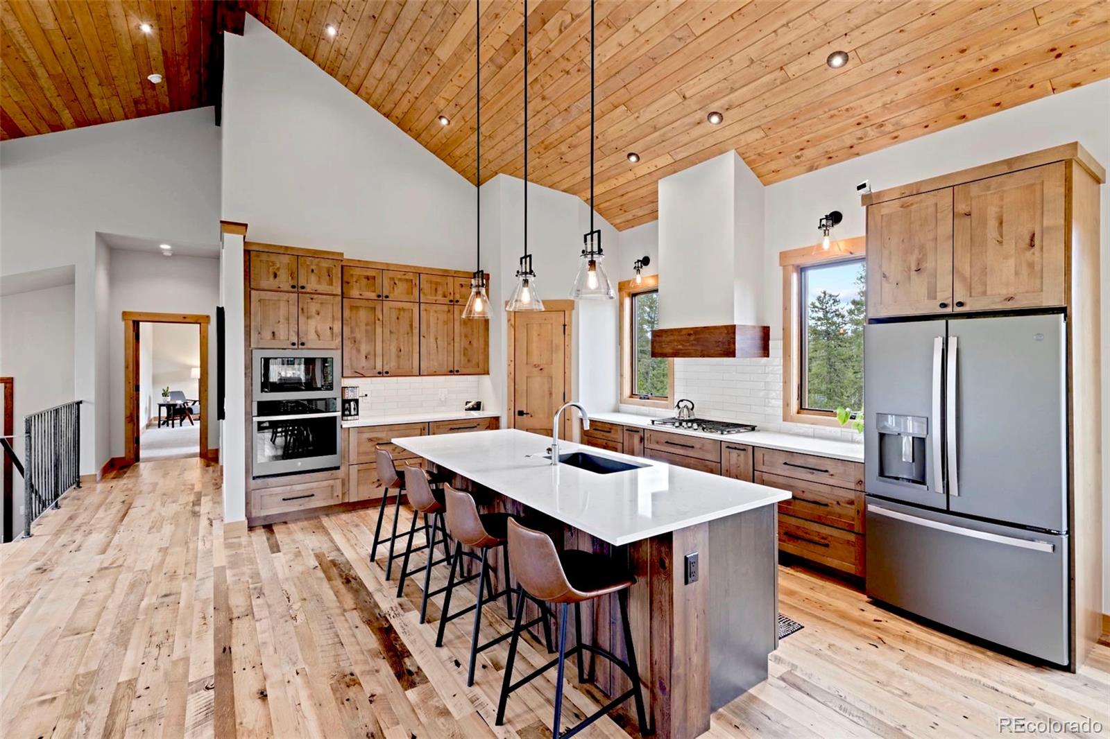 Beautiful wood clad vaulted ceilings give this great room, kitchen and dining room a warm feeling.