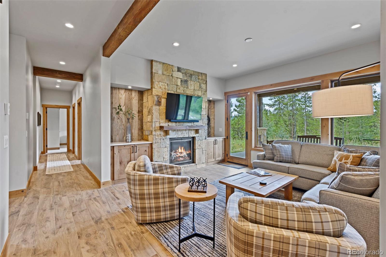 Family room with floor to ceiling stone accent fireplace, leads to a private patio and hot tub under the stars