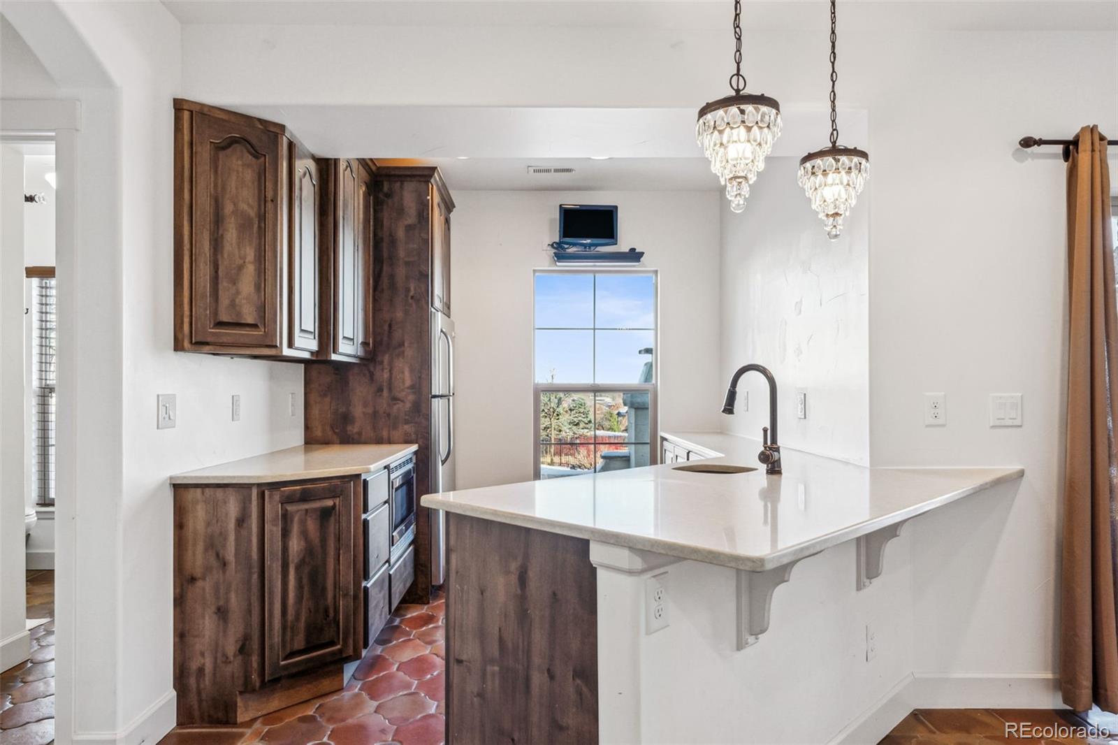 Kitchen in basement with dishwasher, refrigerator and microwave