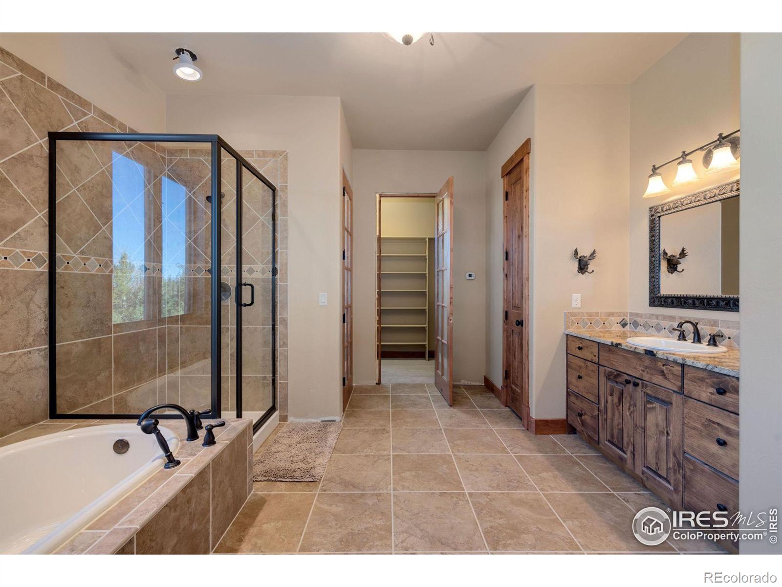 Primary bath with large soaking tub, walk-in shower, private toiletries, sink, linen closet, and walk-in closet