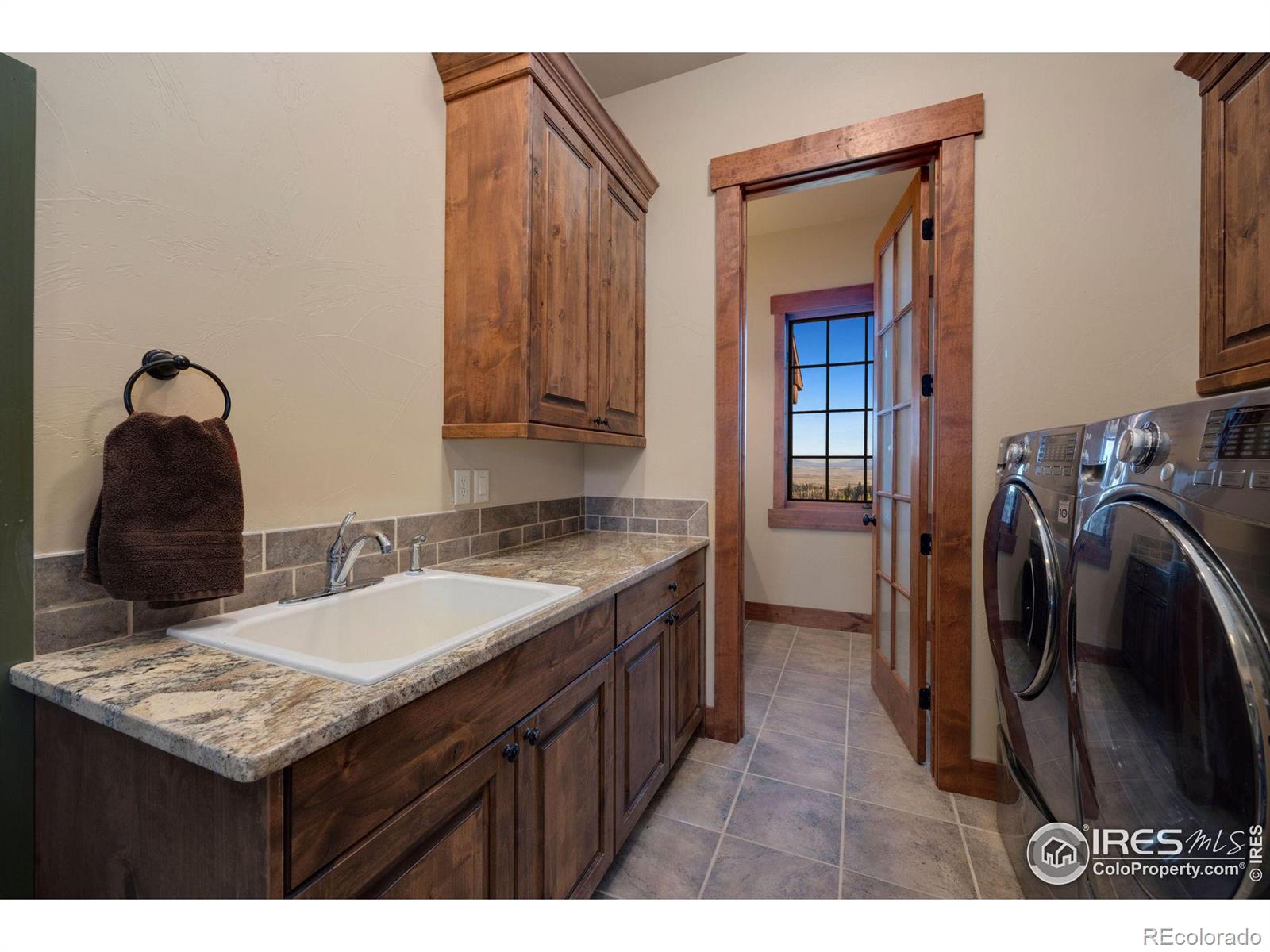 Main floor mud room with sink, washer/dryer additionally adjoining bathroom with sink and shower