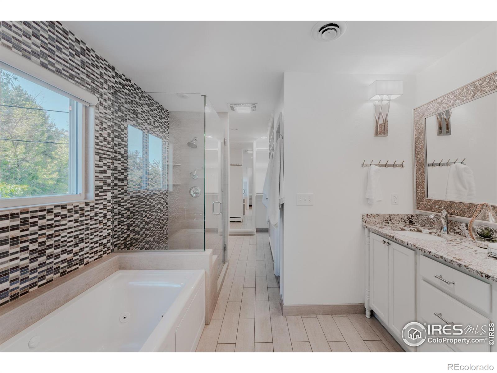 The primary ensuite bath is a serene sanctuary, showcasing dual vanities, a spacious shower, and a generously sized soaking tub equipped with a handheld sprayer.