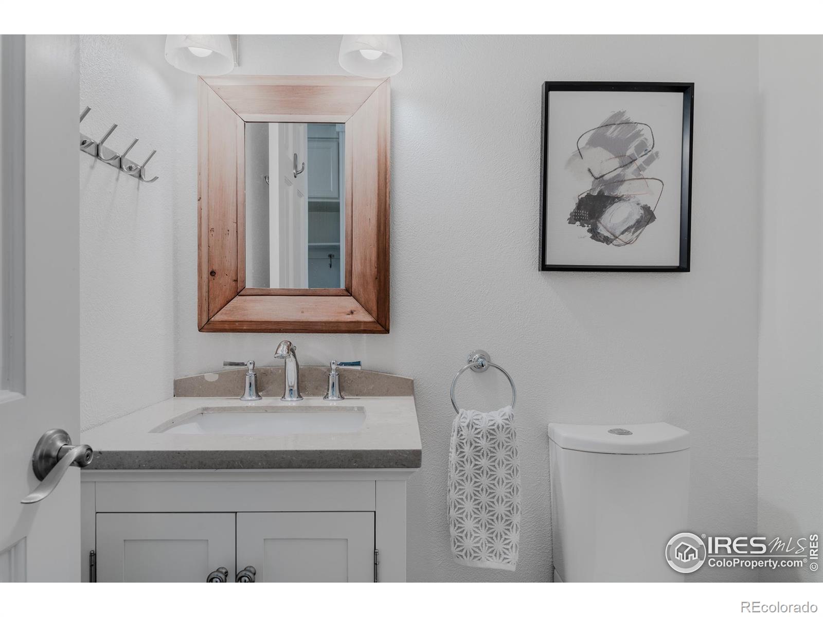 The powder bath features a minimalist design with clean lines, a simple yet elegant vanity, and understated fixtures, creating a serene space.