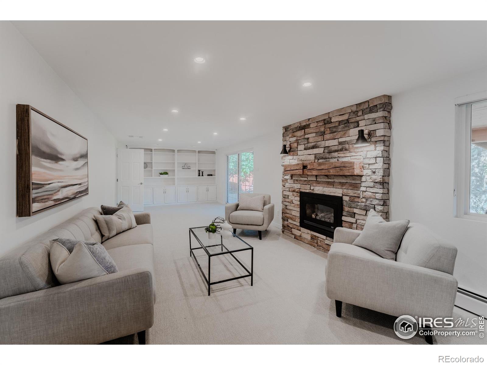 The cozy finished walkout basement is the place, featuring a stone fireplace with a charming barnwood mantel and built in shelving that creates a warm and inviting atmosphere.