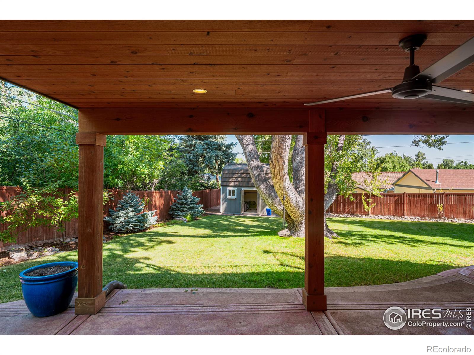 Walk right out onto the patio, shaded by a timber-framed roof and cooled by a ceiling fan, creating a comfortable and inviting outdoor retreat.