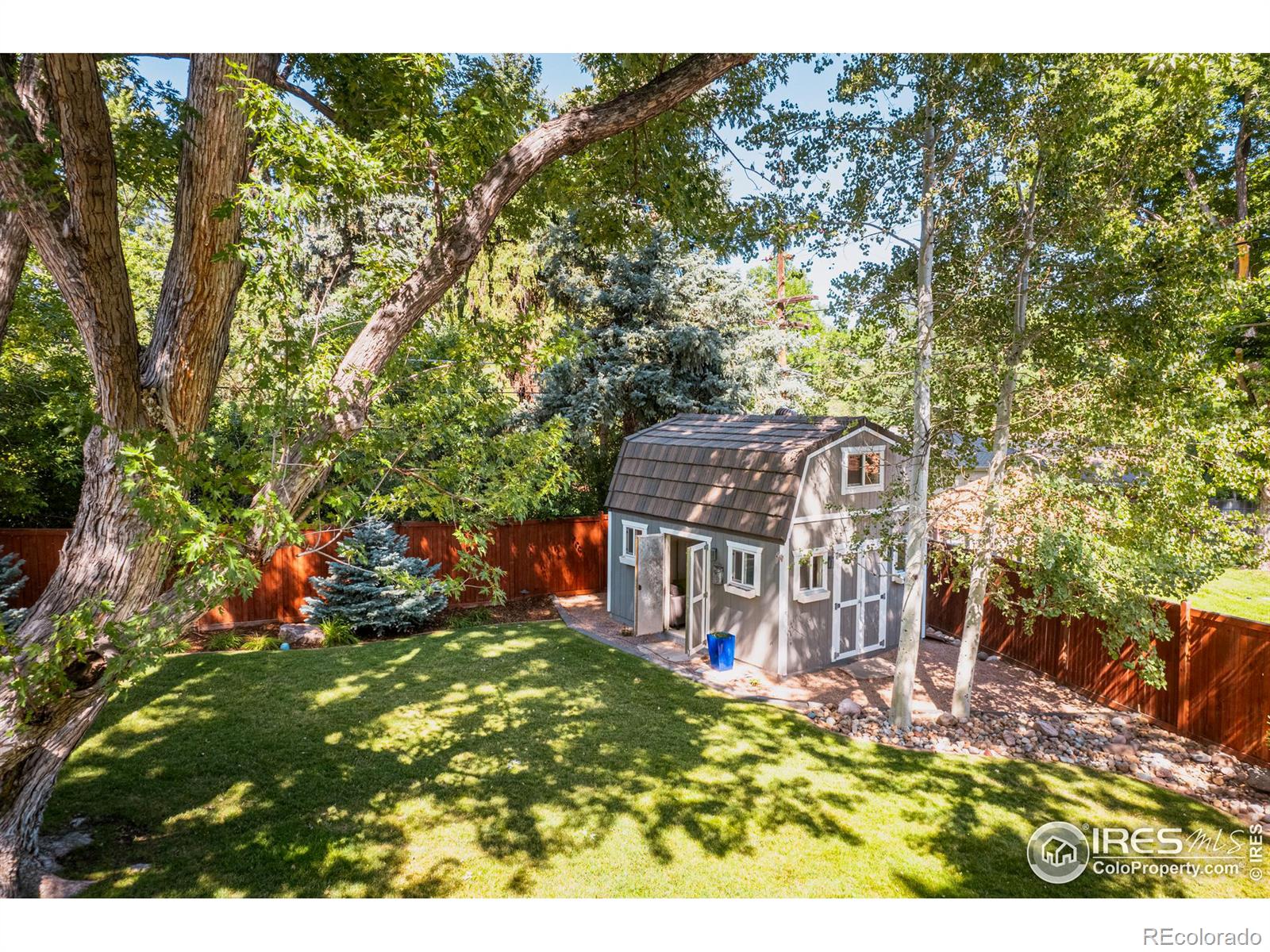 A charming barn style outdoor shed beckons for projects or play, offering a charming and spacious hideaway.