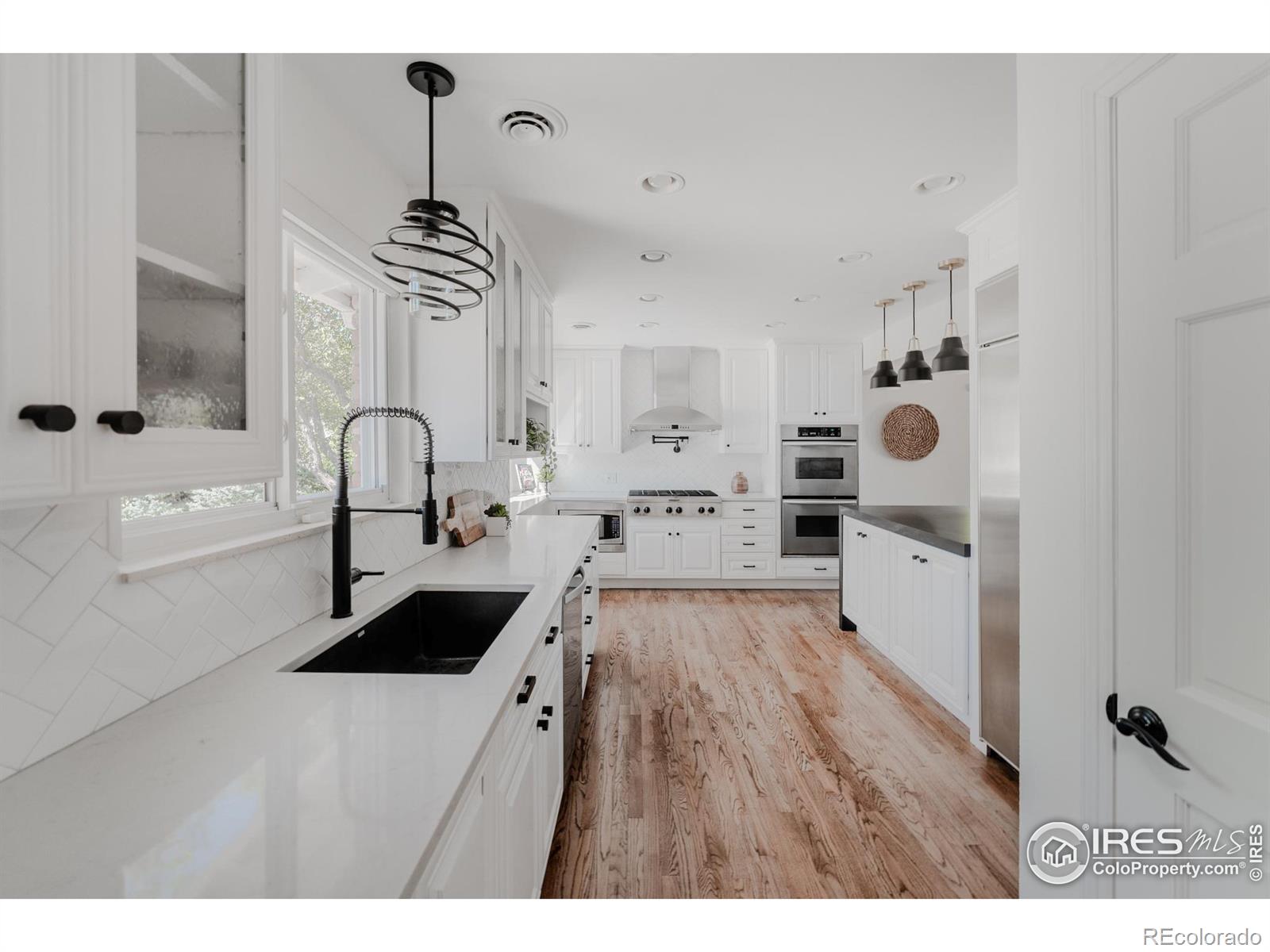 This culinary masterpiece features high-end appliances, including a built in refrigerator, double ovens, a six-burner gas cooktop with a professional hood, and a convenient pot filler, seamlessly blending functionality with style.