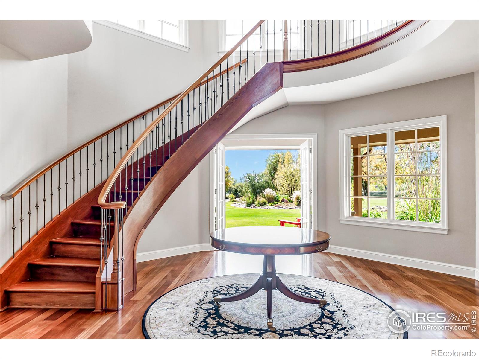 A covered porch and gracious foyer open to the homes show stopping curved staircase, creating a dramatic first impression.