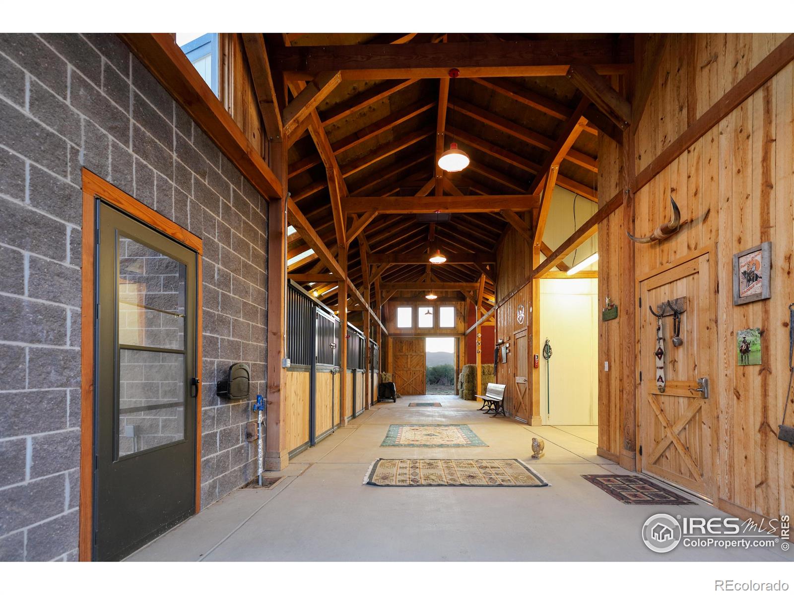 A heated tack room, wash stall, automated waterers & exterior pens, as well as a great room w/ half bath & an attached greenhouse/sunroom