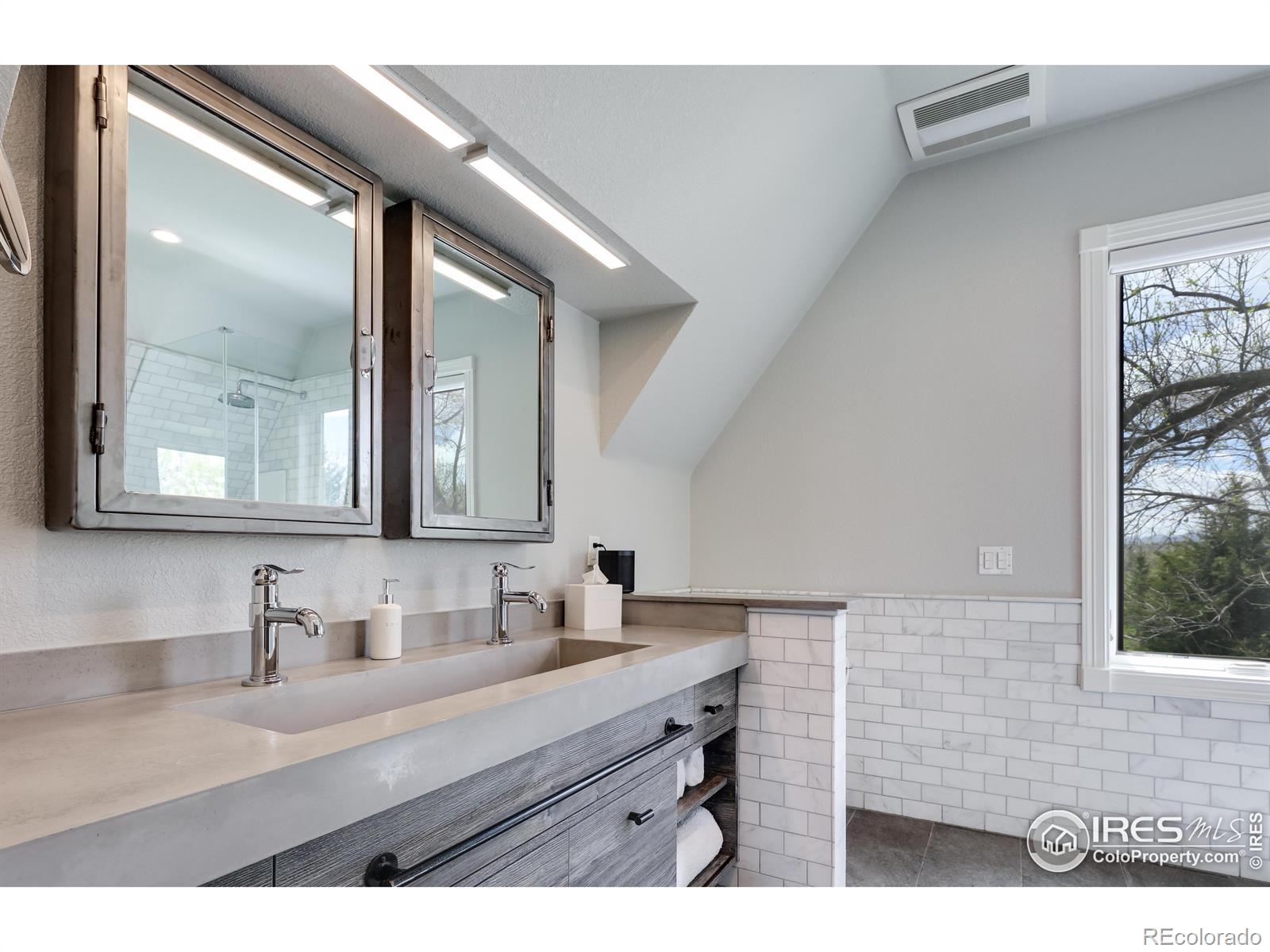 Custom built cement trough sink & marble subway tile throughout primary bathroom paired with MTI Stone tub and shower basin