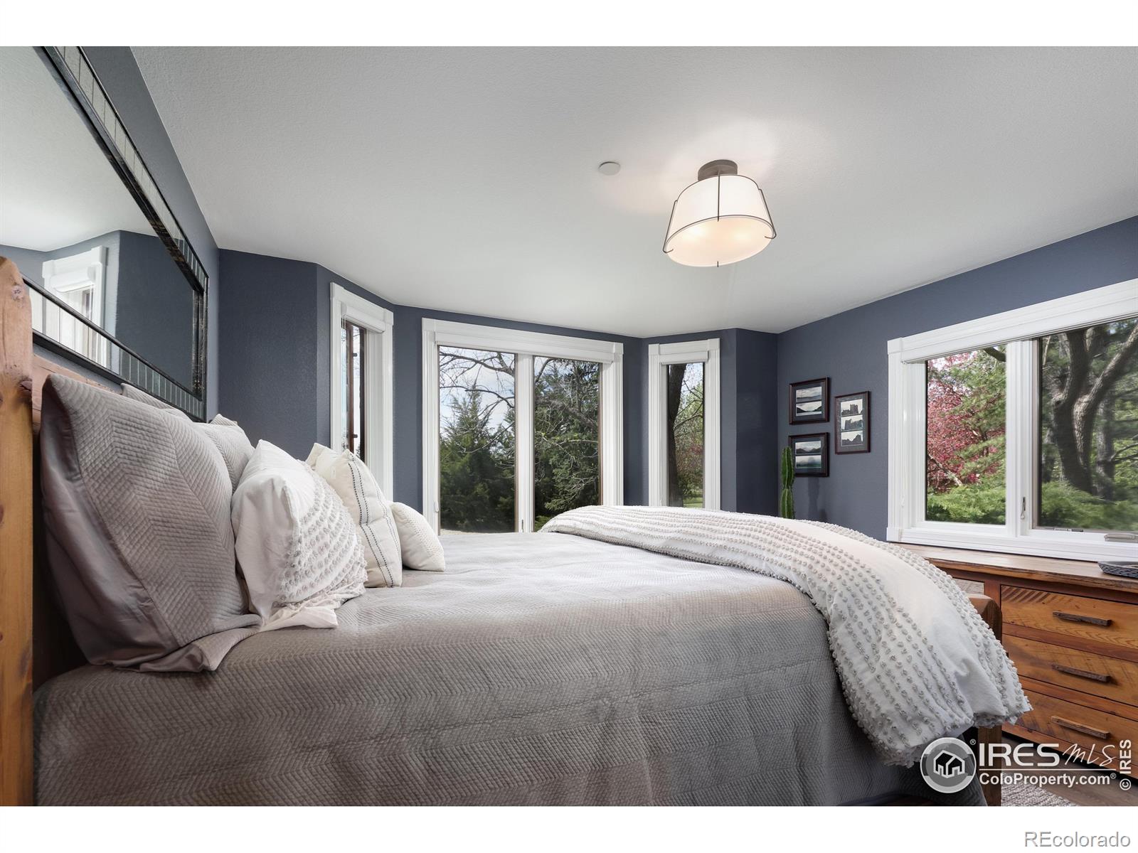 Inviting bedroom 2 on the main level enveloped in lush, mature trees