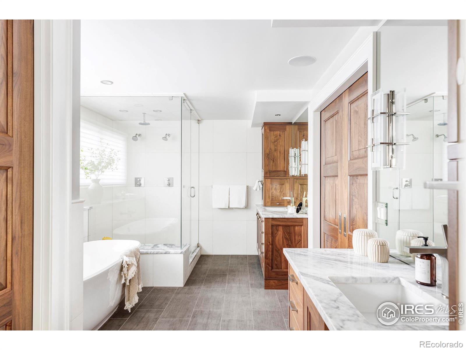 Generous closet space attends to wardrobe needs, and double pocket doors reveal a magazine-worthy spa bathroom with a Victoria & Albert soaking tub, glass shower, separate large walnut vanities and heated floors.