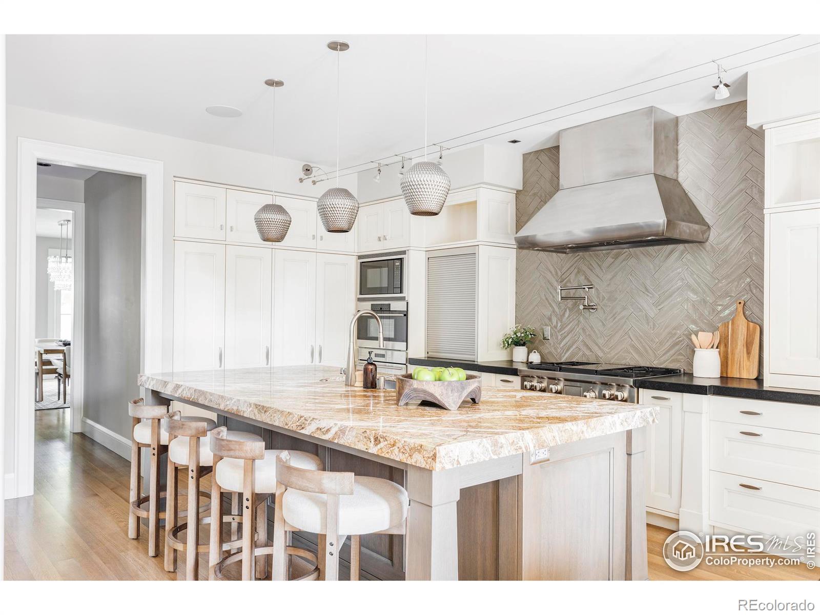 The work-of-art kitchen by William Ohs is anchored by a massive Saint Laurent marble breakfast bar/island.