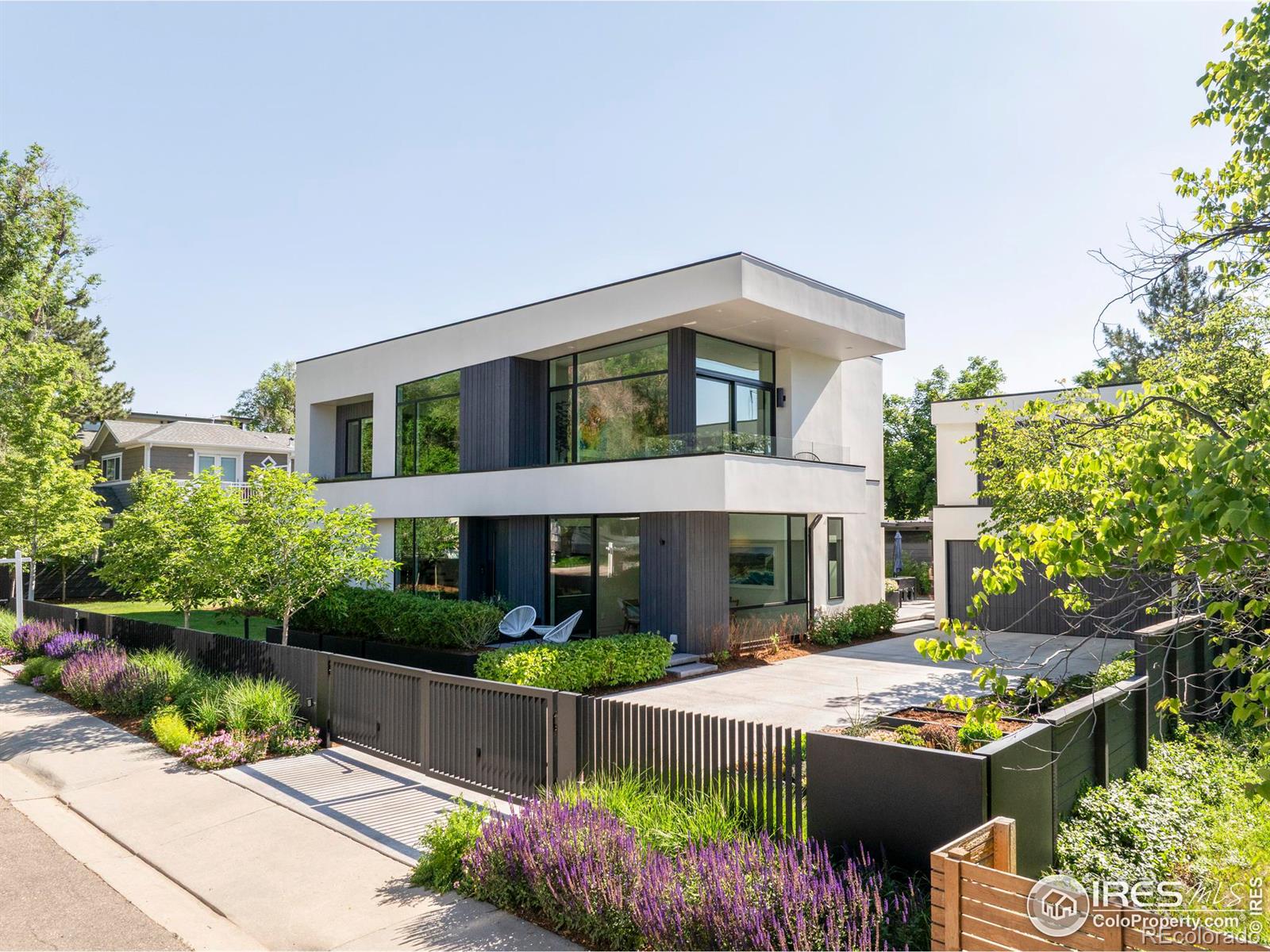 Outside, this unrivaled sanctuary is fully encircled by a modern slatted steel fence and a gated driveway entrance.