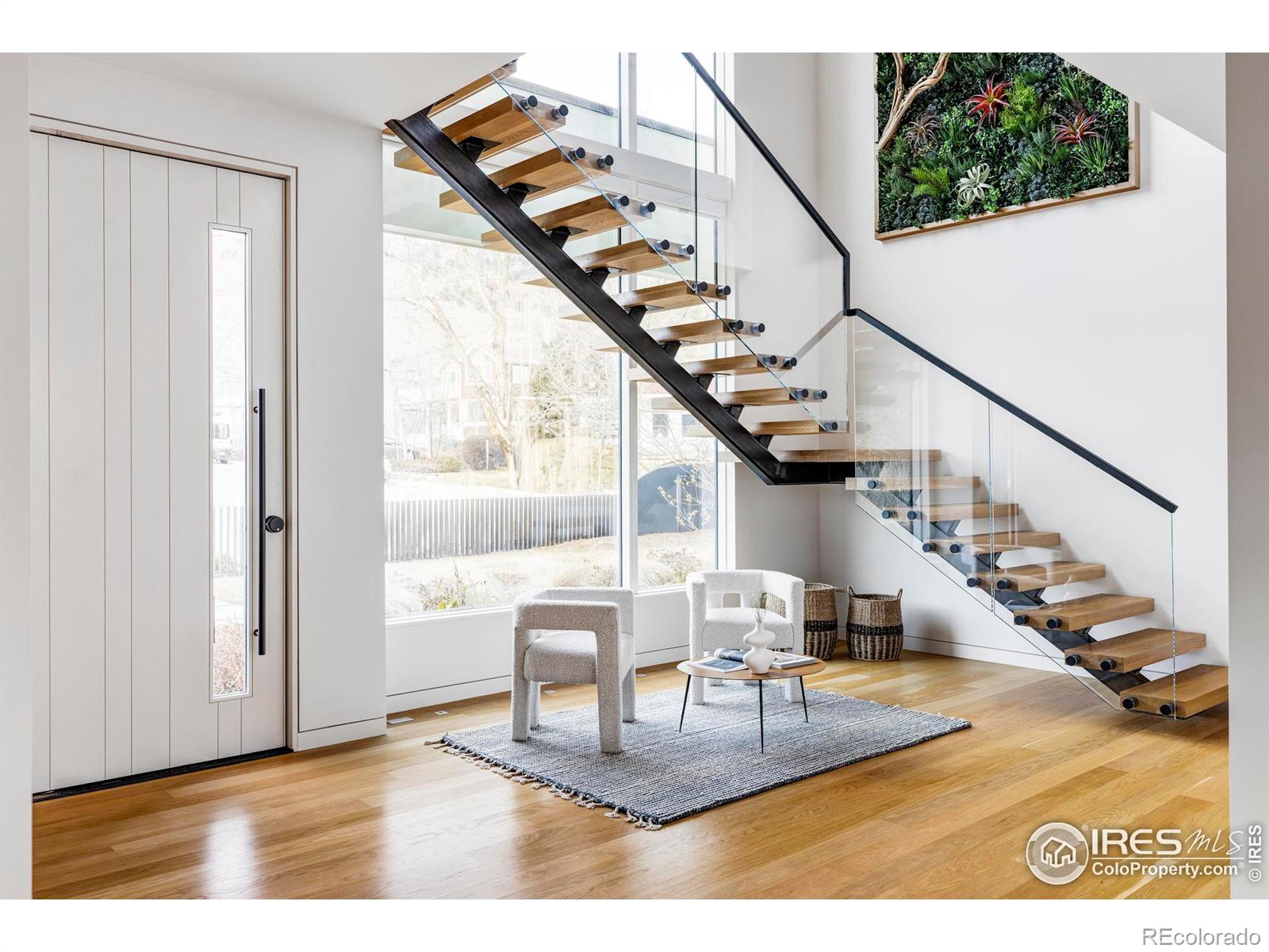 A custom pivot door opens to an inviting foyer surrounded by closets and a convenient powder room.