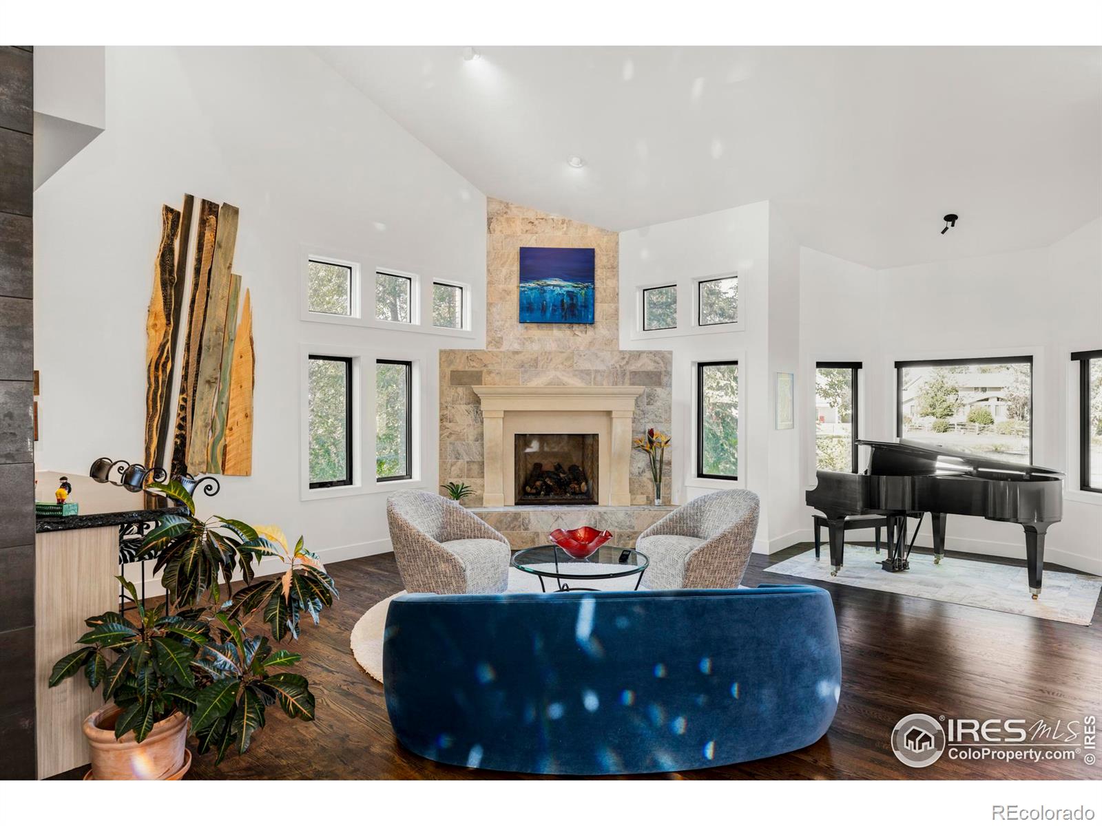 An elegant foyer with soaring vaulted ceilings showcases a floating  staircase crafted from reclaimed steel and boxcar flooring.