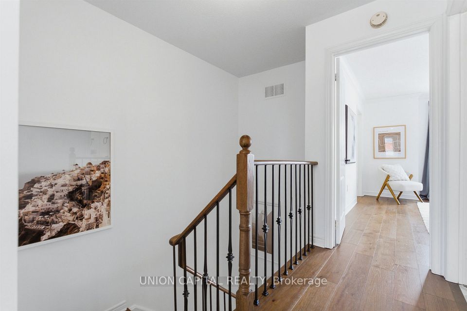 HARDWOOD STAIRS WITH IRON PICKETS & MODERN LIGHTS