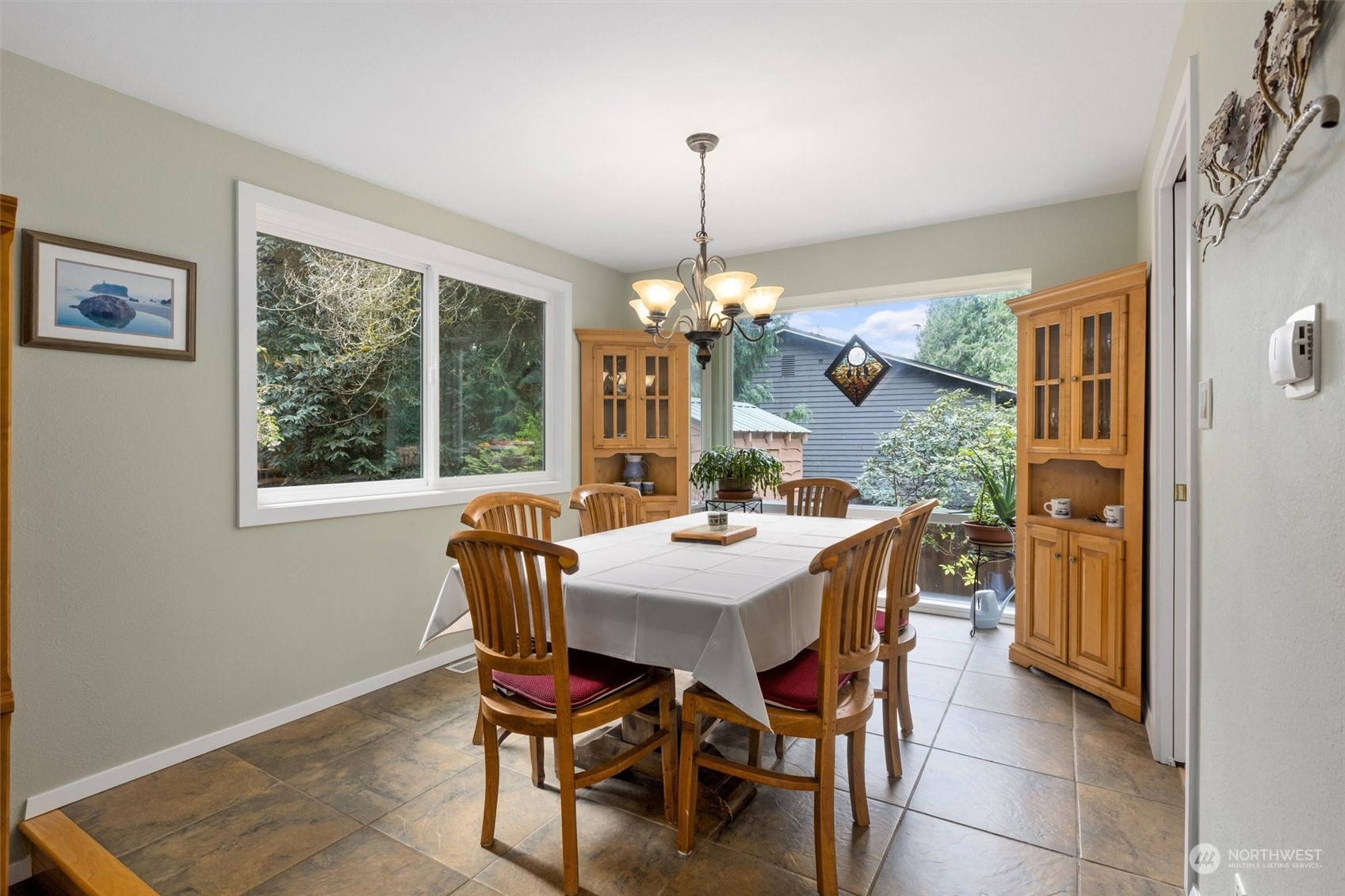Sun-filled dining room with floor to ceiling atrium window, looking out to private yard, garden and wildlife at play.  Great space for anytime of the day.