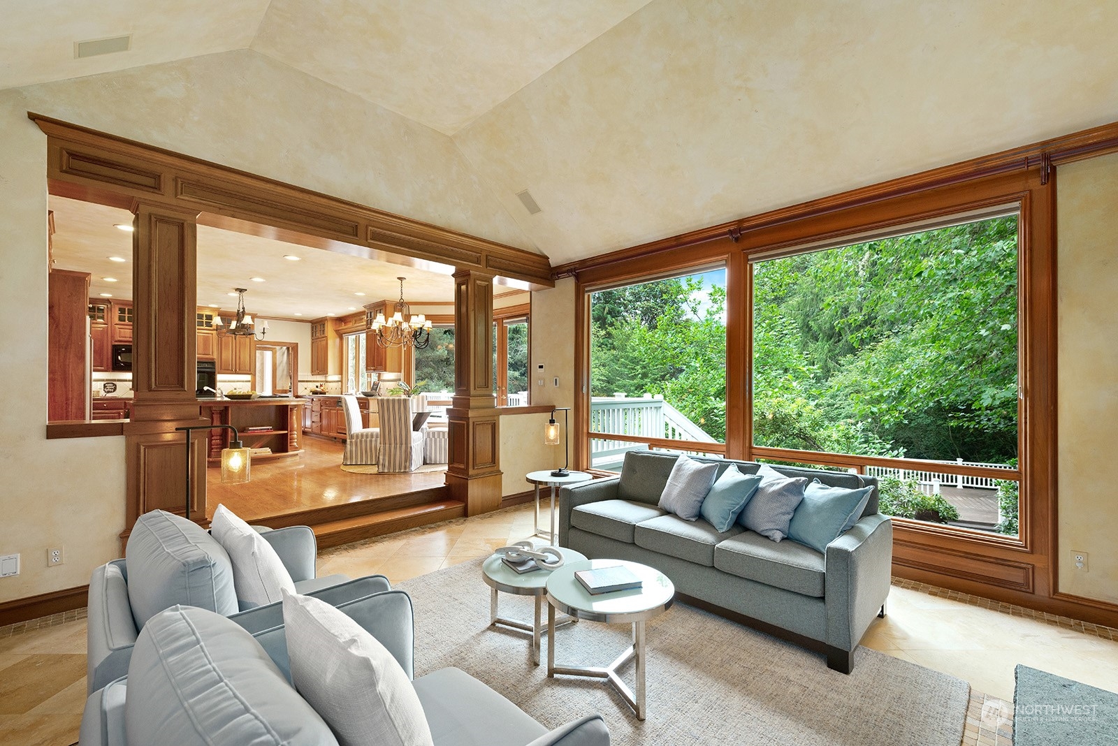 Family room with a wall of windows and a view of the ground level second deck.